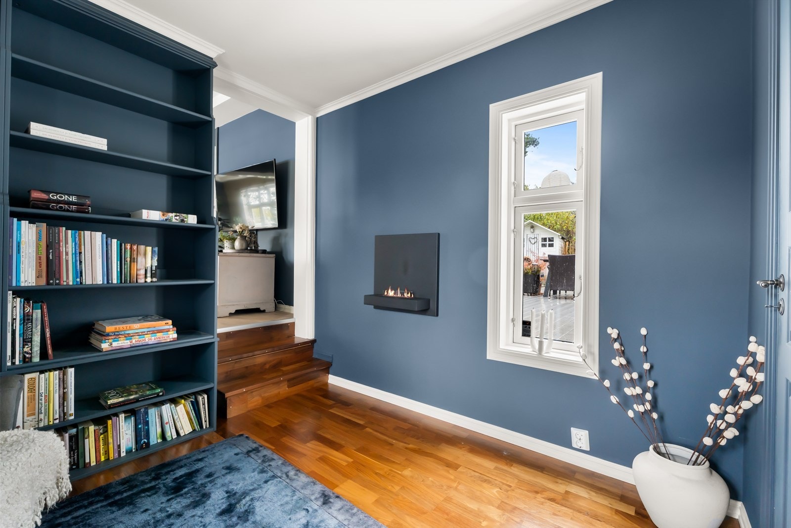 Bibliotek med gassovn og utsyn mot bakgården Galleribilde