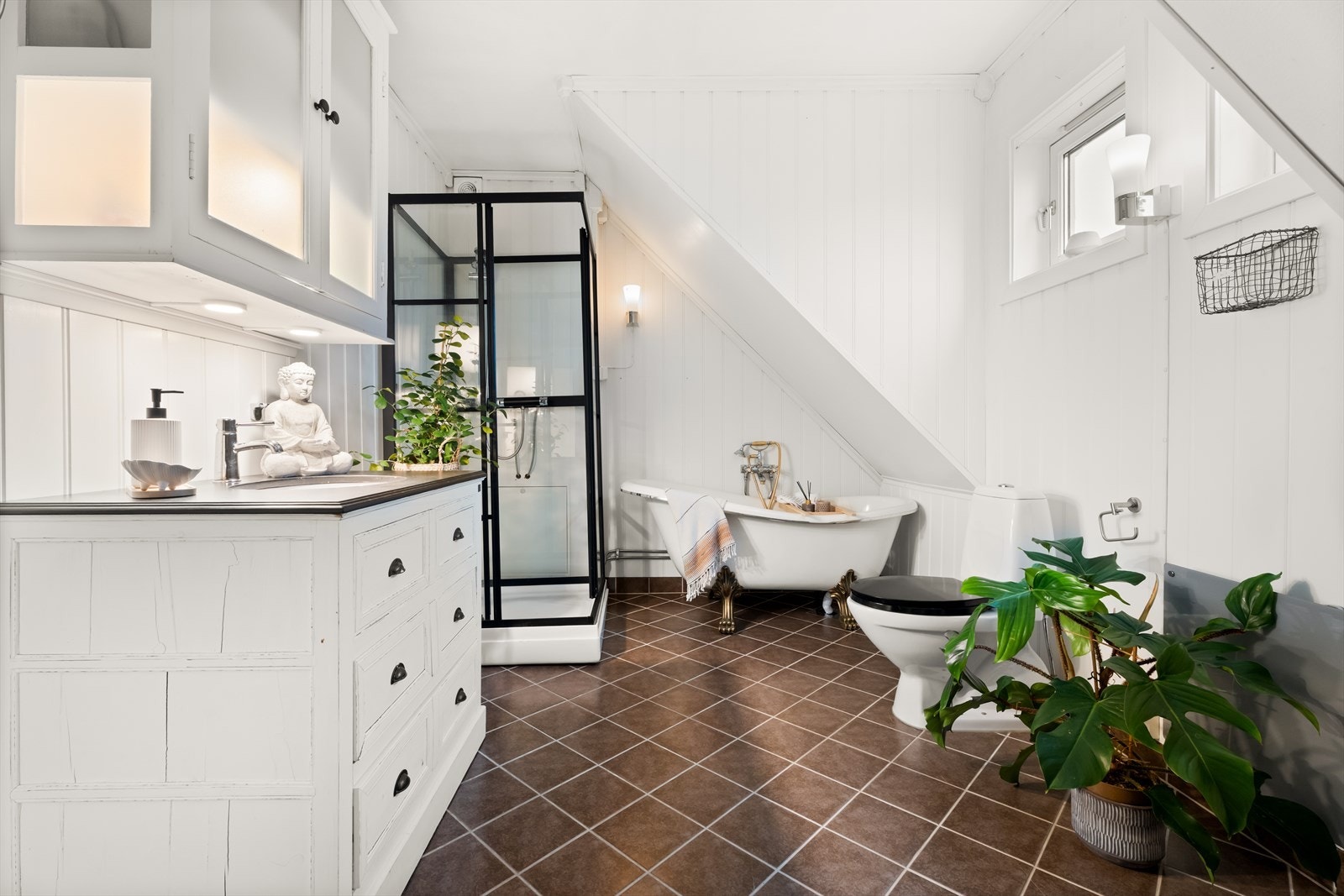 Badet i andre etasje bærer preg av husets karakter. Her er det koselig badekar, lyst panel og dusjkabinett. Galleribilde