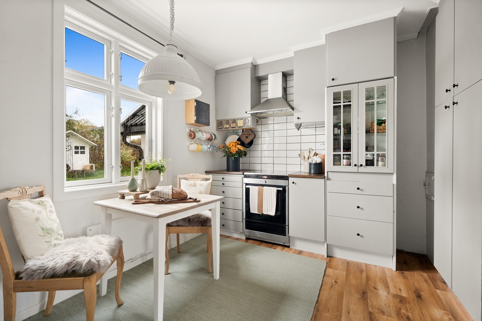 Kjøkken med koselig spiseplass og utsyn mot hagen Galleribilde