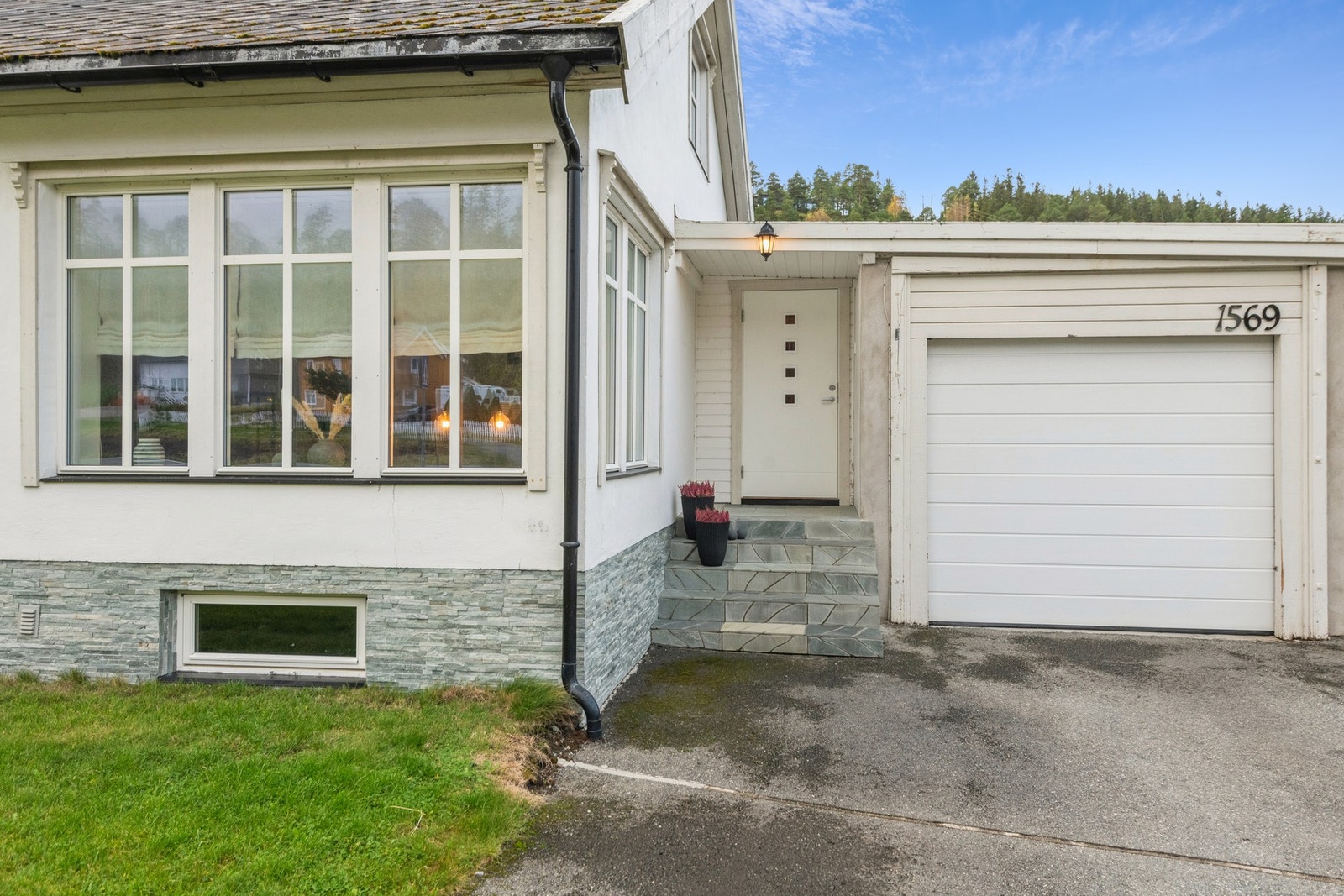 Inngangspartiet har en steinlagt trapp og asfaltert gårdsplass. Boligen har en svært romslig garasje. Galleribilde