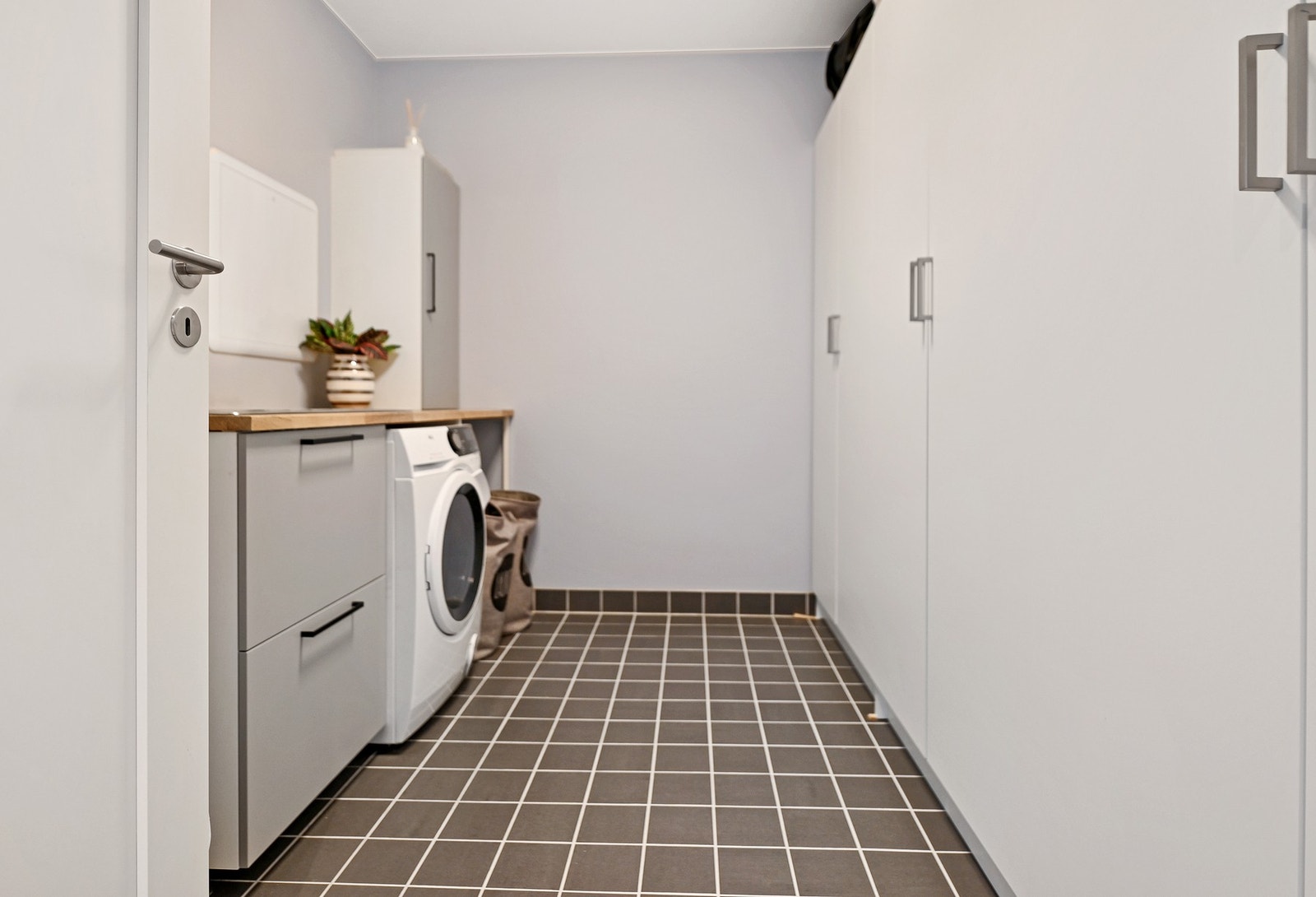 Alle foreldre og hundeeieres drøm - et stort og praktisk vaskerom i underetasjen. Her kan man ta med ungene rett hjem fra barnehagen og kaste parkdressen i vaskemaskinen. Rommet er innredet med utslagsvask og opplegg for vaskemaskin. Galleribilde