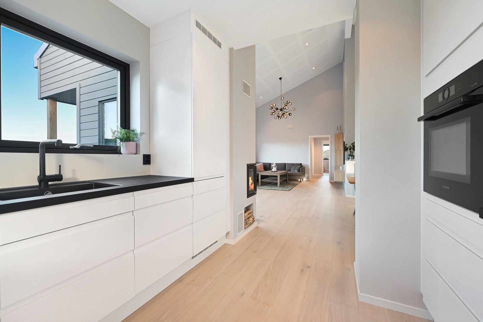 Kjøkkenet ligger i åpen løsning mot stuen. Den åpne løsningen lar det naturlige lyset strømme inn i rommet, skaper en behagelig atmosfære, og gir muligheten til å ha visuell kontakt med resten av hjemmet. Galleribilde