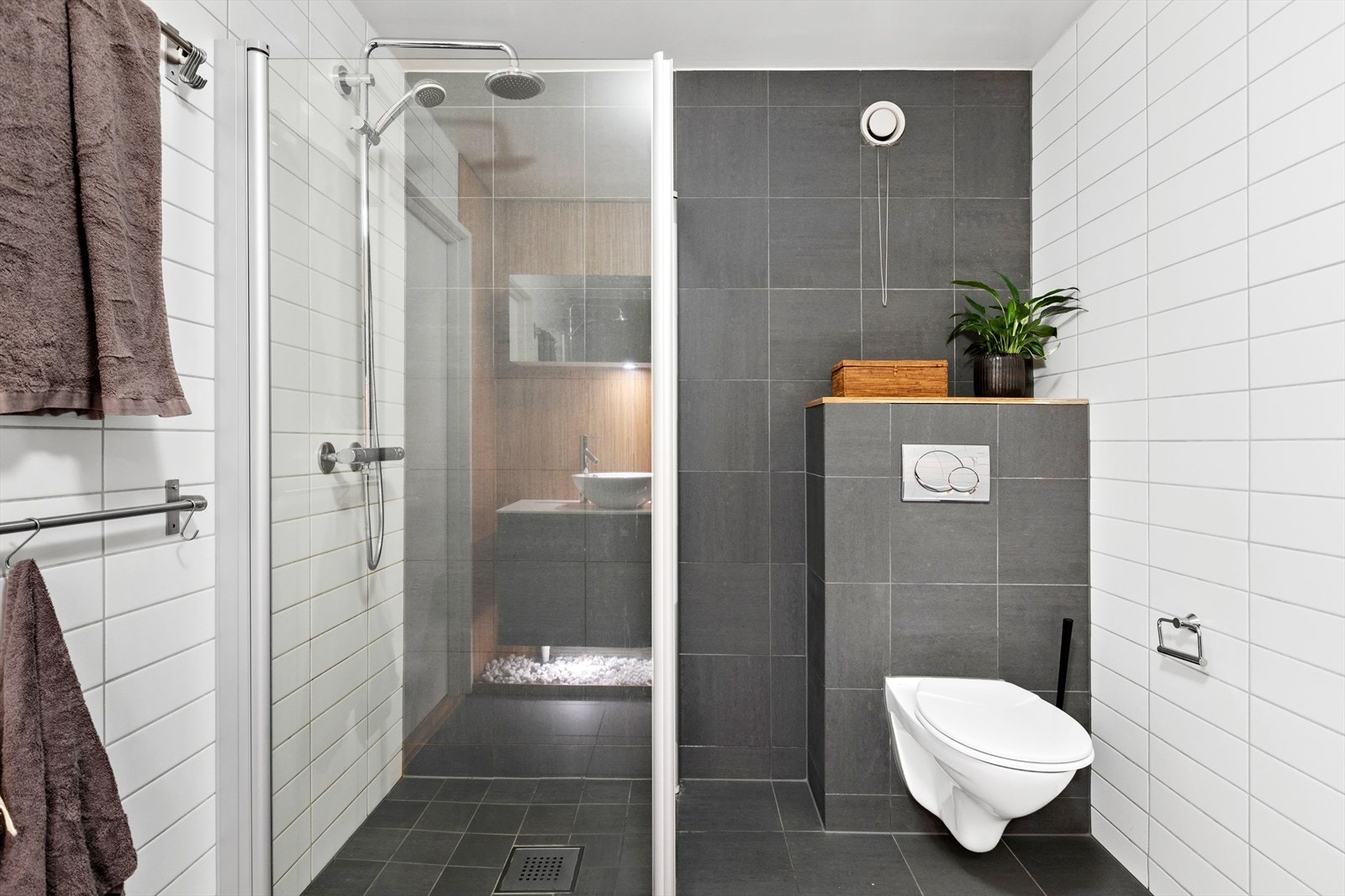 Badet er utstyrt med vegghengt toalett, vermekabler i gulv, dusjhjørne, servant og servantskap. Galleribilde