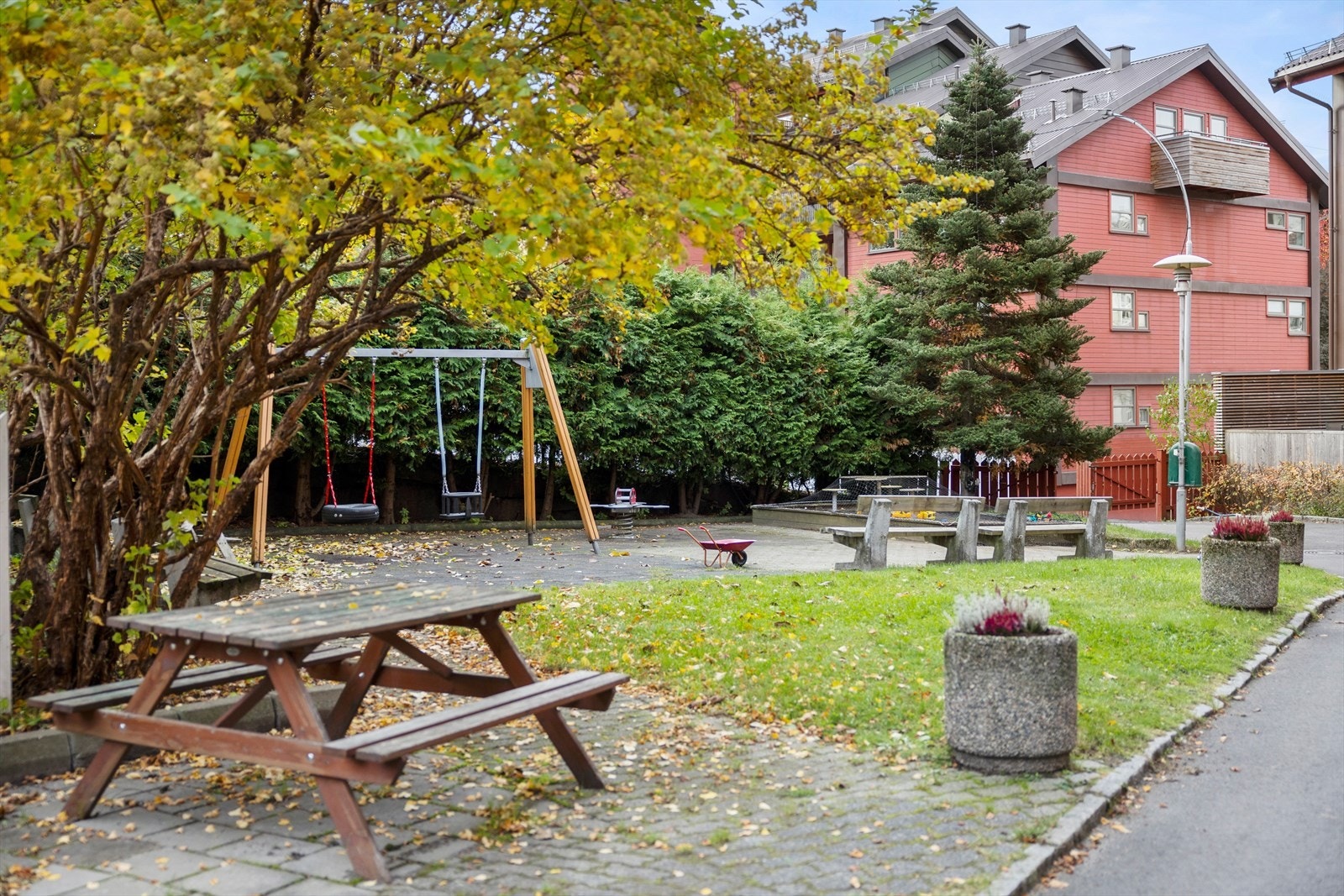Fellesområdet har benker, lekeapparater og beplanting. Galleribilde