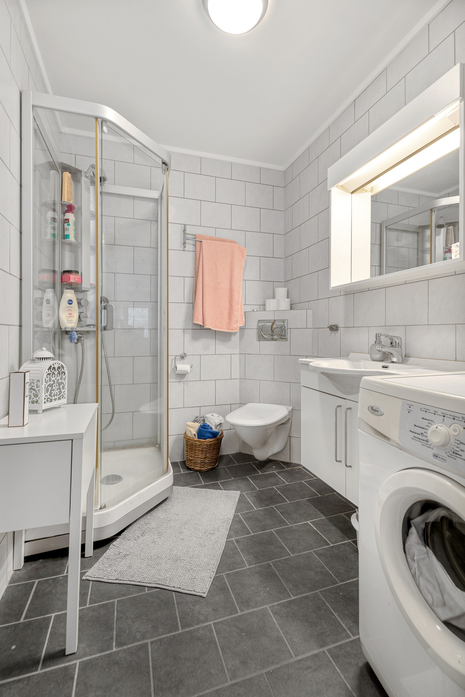 Flislagt bad/vaskerom i hybel med vegghengt wc og dusj Galleribilde