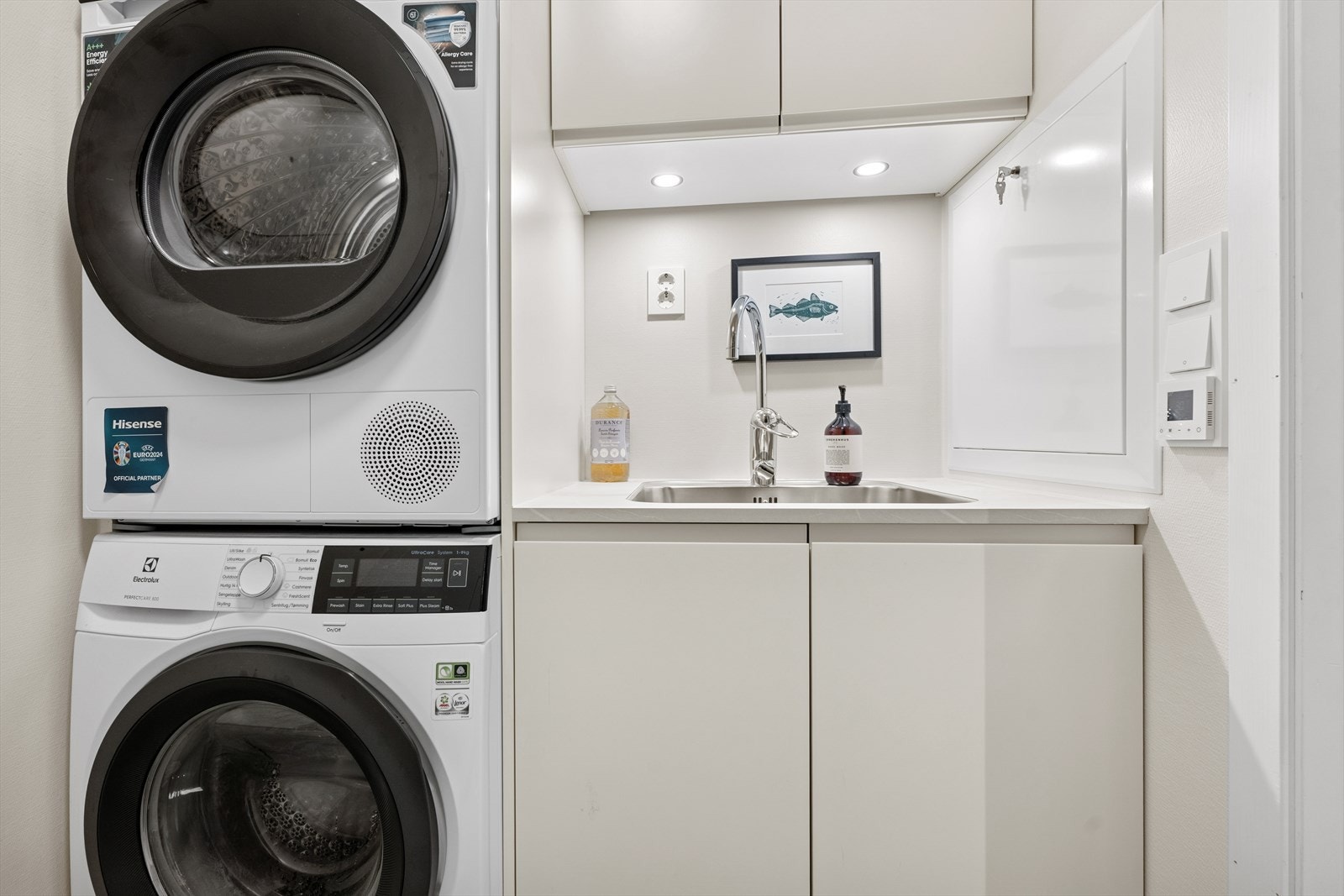 Vaskerommet har innredning med utslagsvask, skap og opplegg for vaskemaskin/tørketrommel Galleribilde