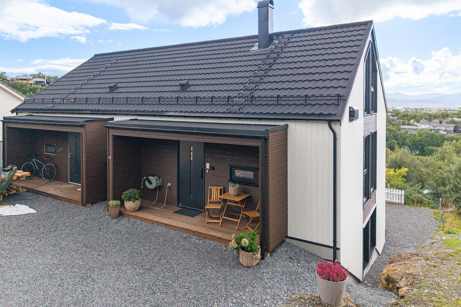 Inngangspartiet til boligen er overbygget, utstyrt med slangetrommel og inngangsdør med kodelås Galleribilde