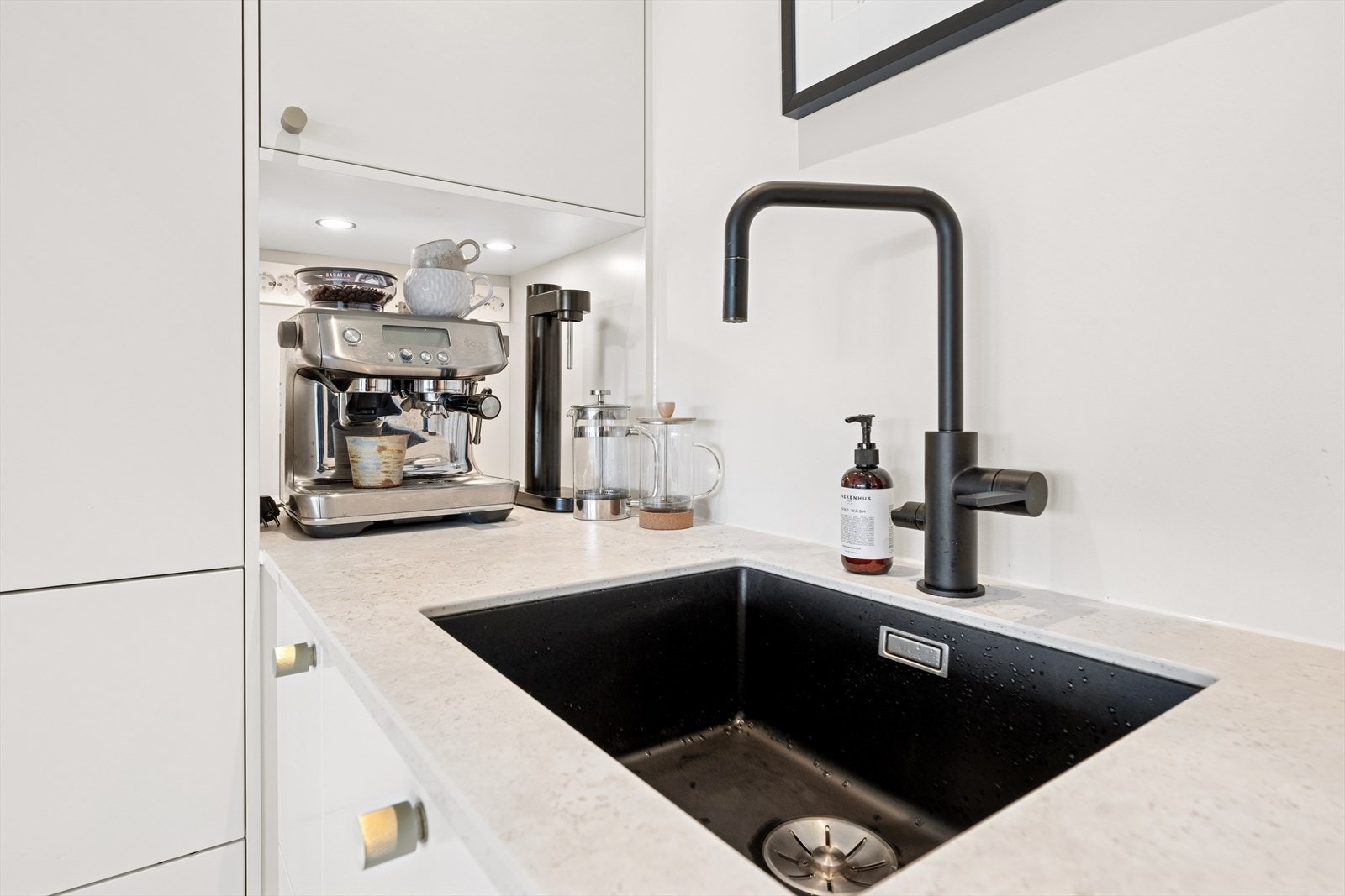 Legg merke til den flotte detaljene som downlights under overskapene og underlimt sort servant Galleribilde