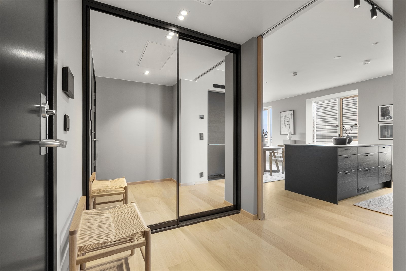 Man ønskes velkommen inn i en lys og innbydende entré med innebygget skyvedørsgarderobe som gir godt med oppbevaringsplass. En skyvedør skiller entréen fra oppholdsrommet - praktisk og stilrent. Galleribilde