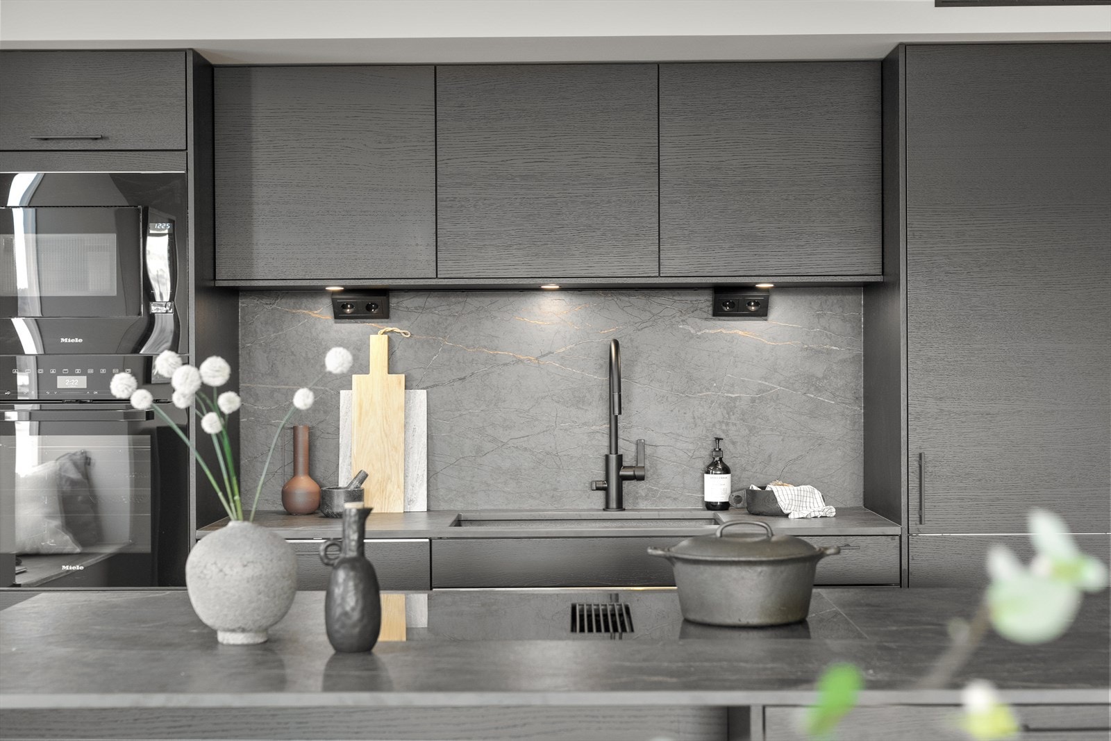 Alt av hvitevarer er integrert - kjøl- og fryseskap i høyskap, oppvaskmaskin, stekeovn, induksjonstopp og ventilator med mekanisk avtrekk. Galleribilde