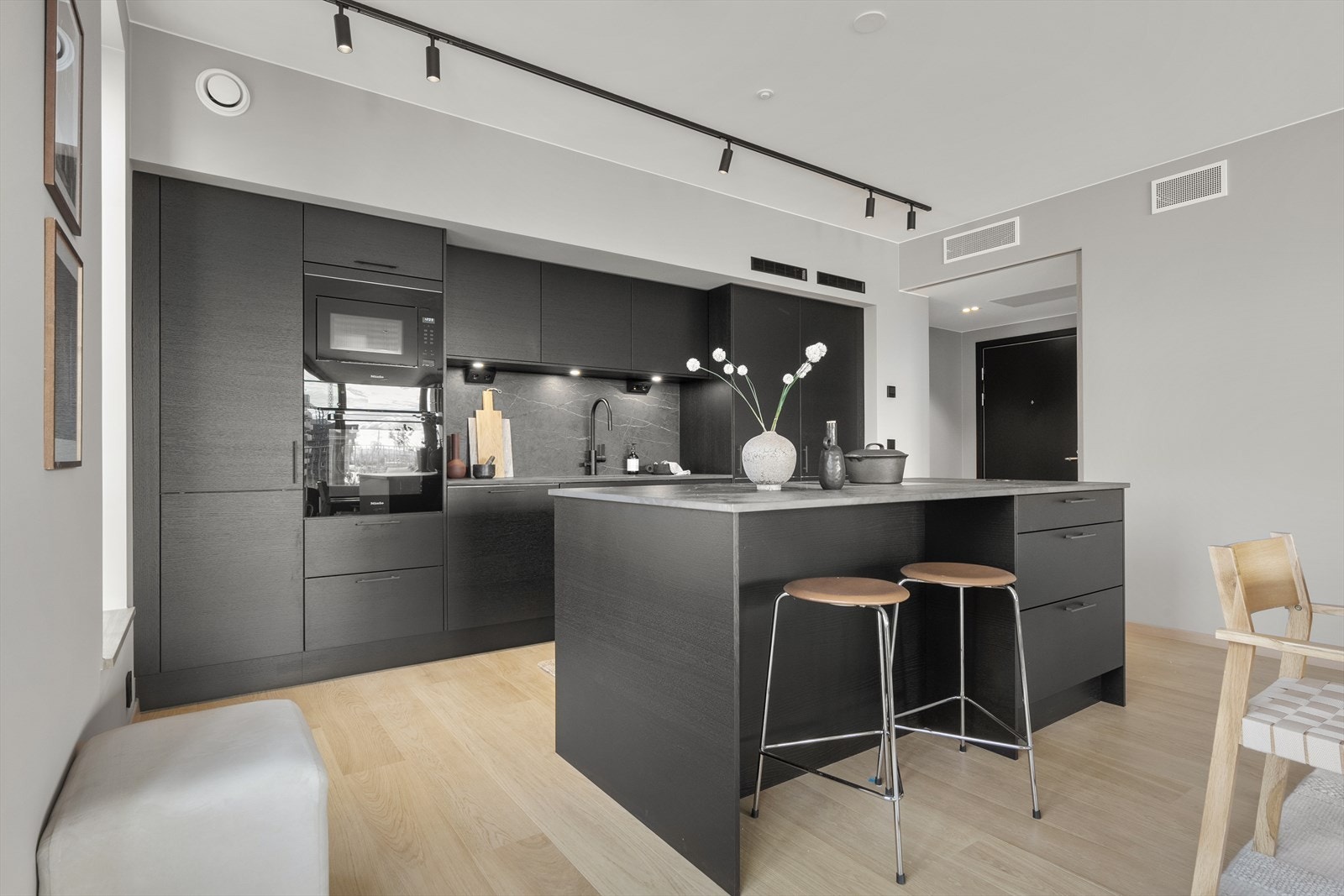 Flott kjøkkeninnredning med fullintegrerte hvitevarer og kompositt benkeplate Galleribilde