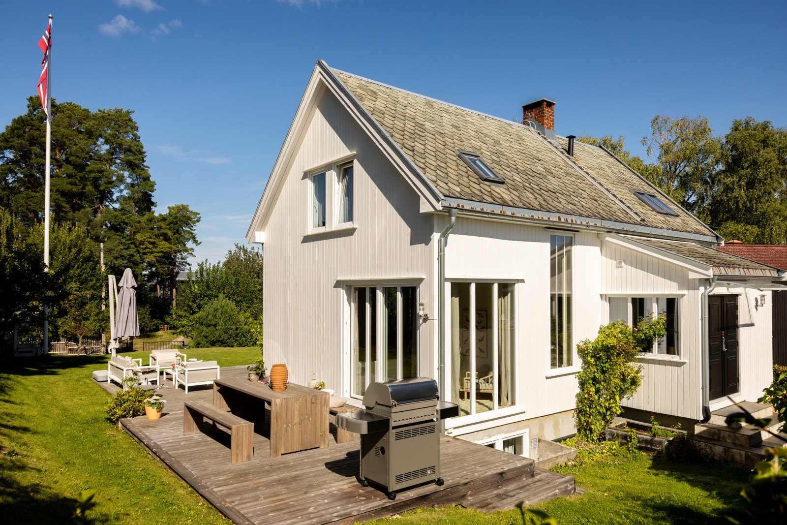 Det er en stor og flat hage med mye sol, som er pent opparbeidet med busker og fruktrær, samt en terrasse. Galleribilde