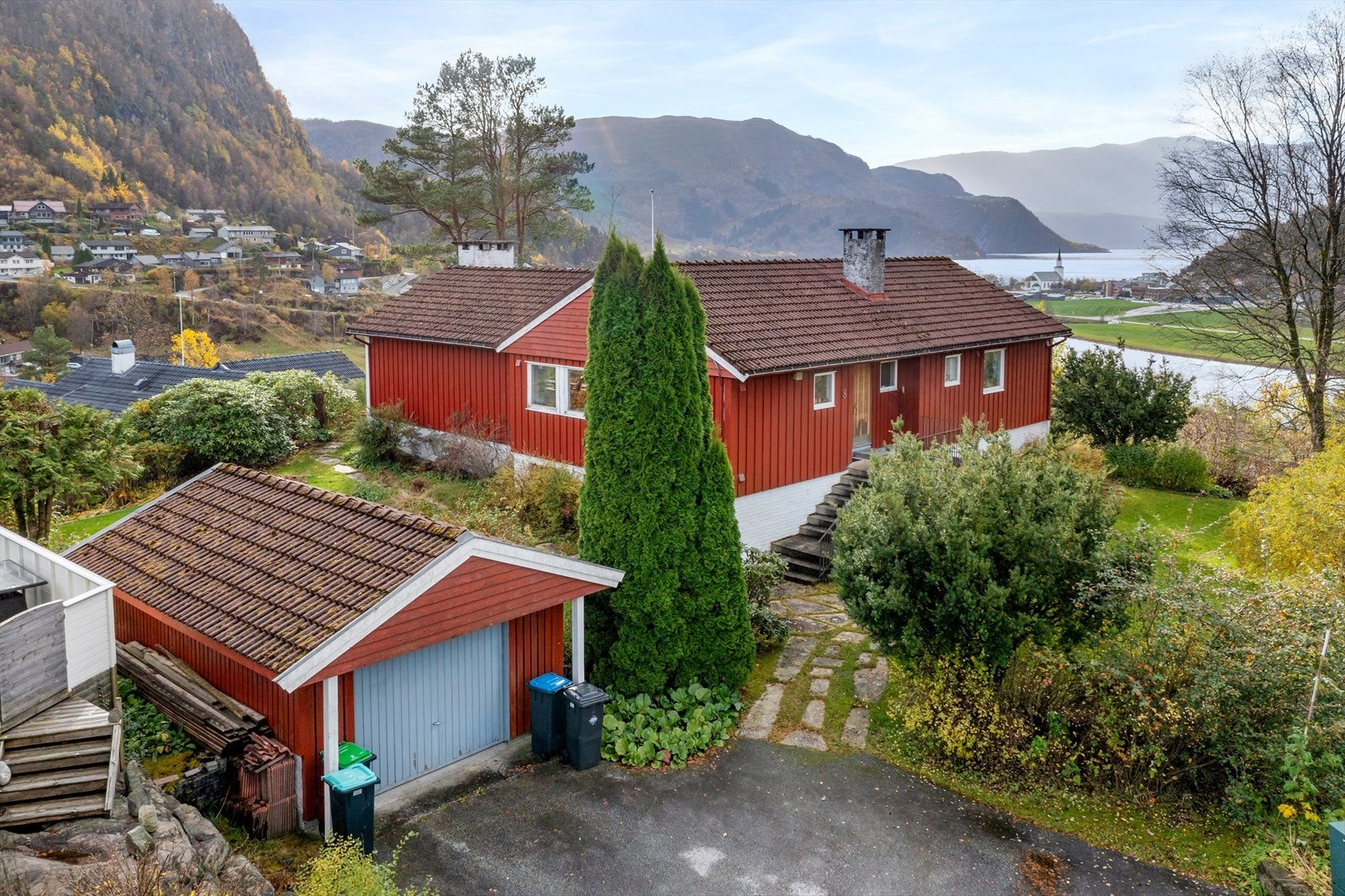 Asfaltert tilkomst til frittståande garasje. Steinheller leiar inn til trappeoppgangen Galleribilde