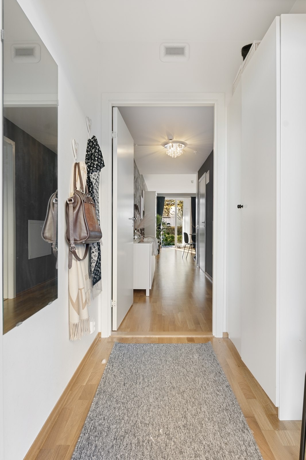 Gangen har gjennomgående parkett på gulv og leder videre inn i leiligheten. Galleribilde