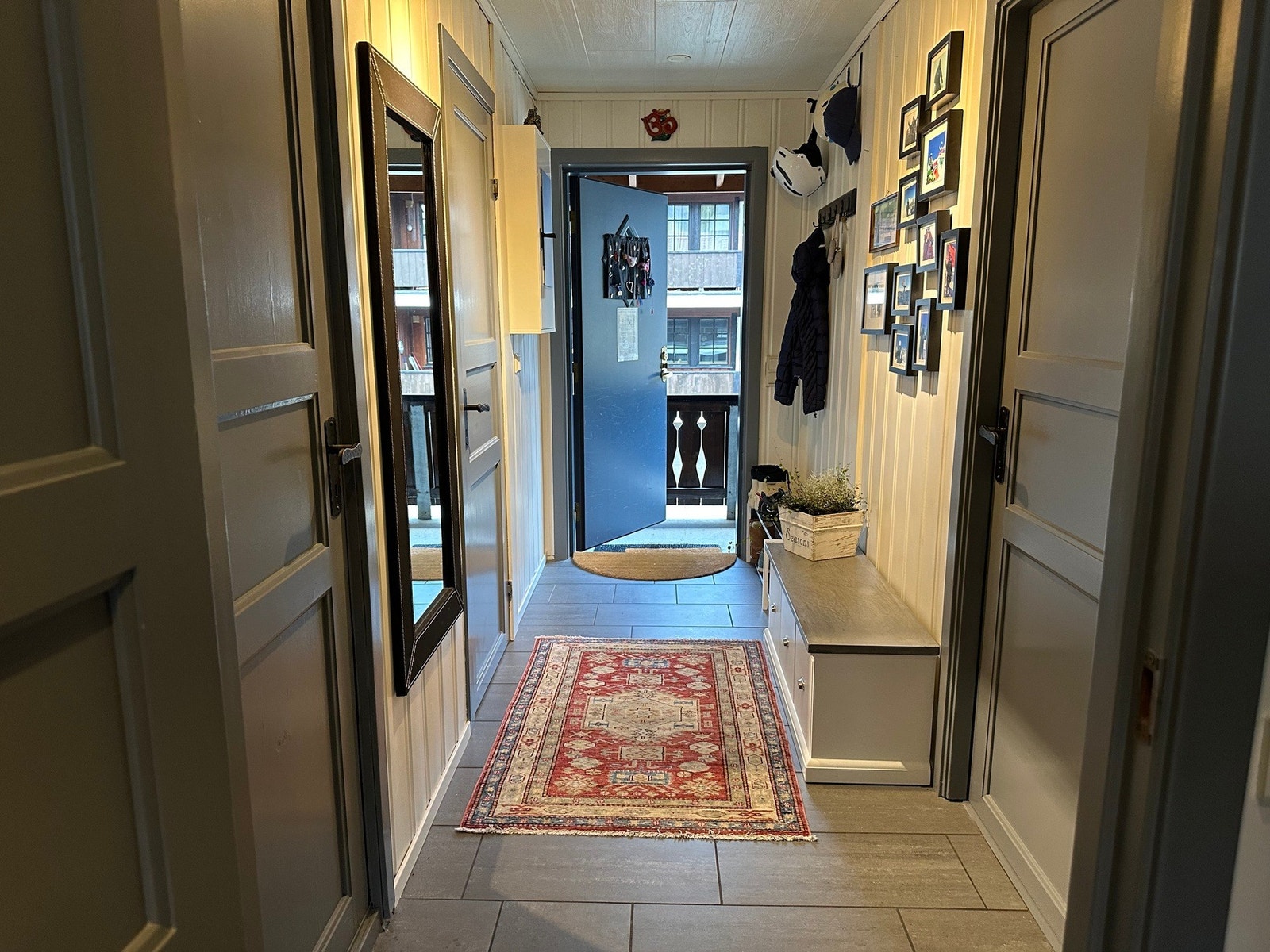 Velkommen inn! Flislagt gulv og panel gir en praktisk og hyggelig entré Galleribilde