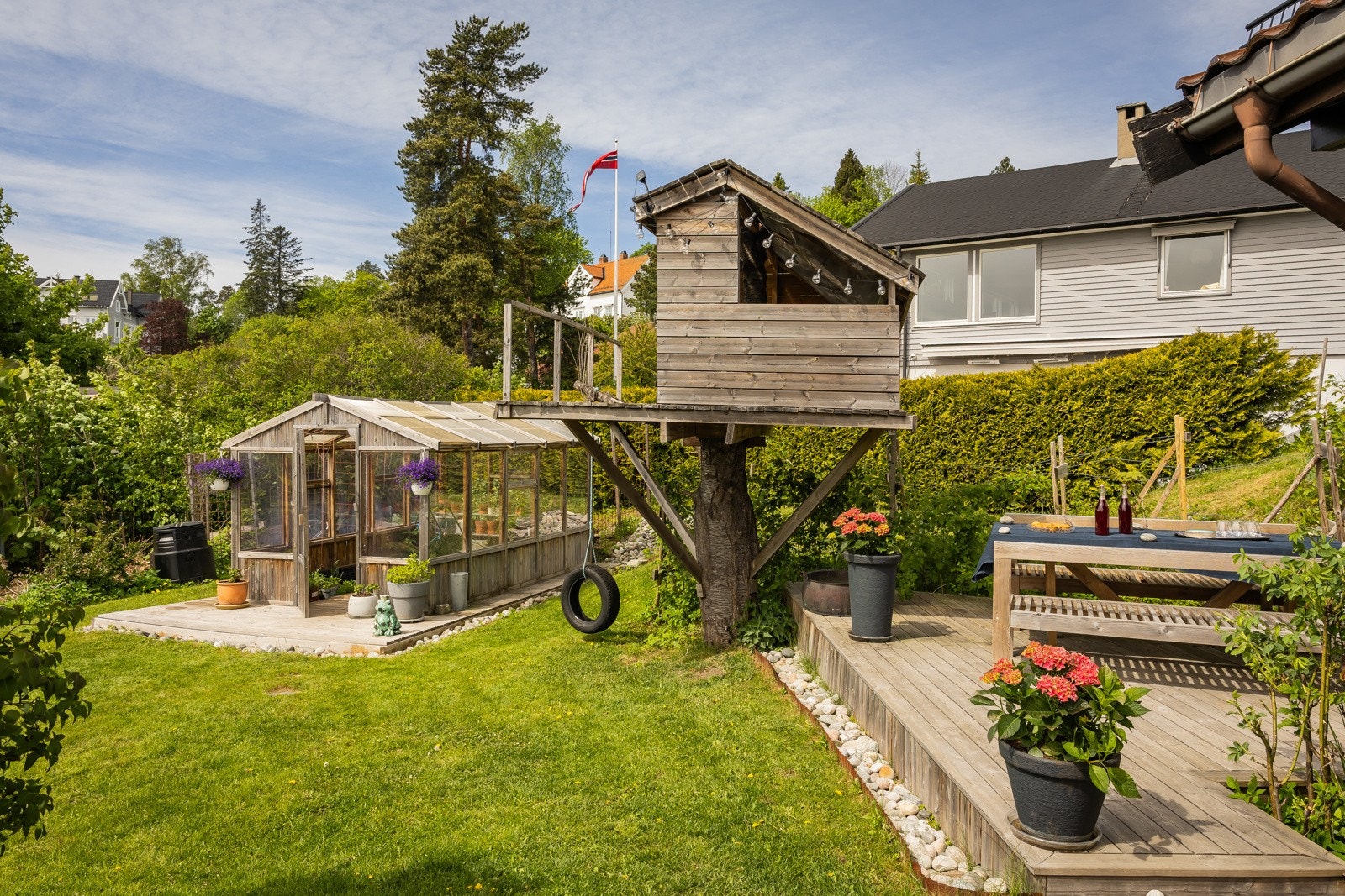 Det er bl.a. drivhus, potetåker, bærbukser og trehytte i hagen Galleribilde