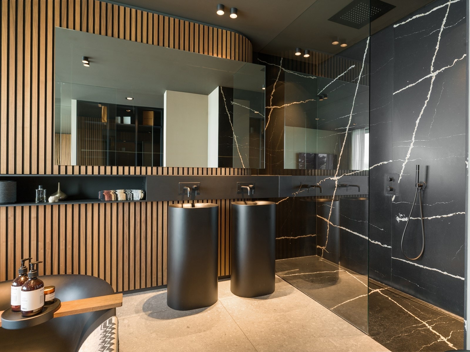 Hovedbadet byr på nedsenket dusjsone med heldekkende Silestone-plater og glassvegg mot soverommet, en sømløs kombinasjon av velvære og design Galleribilde