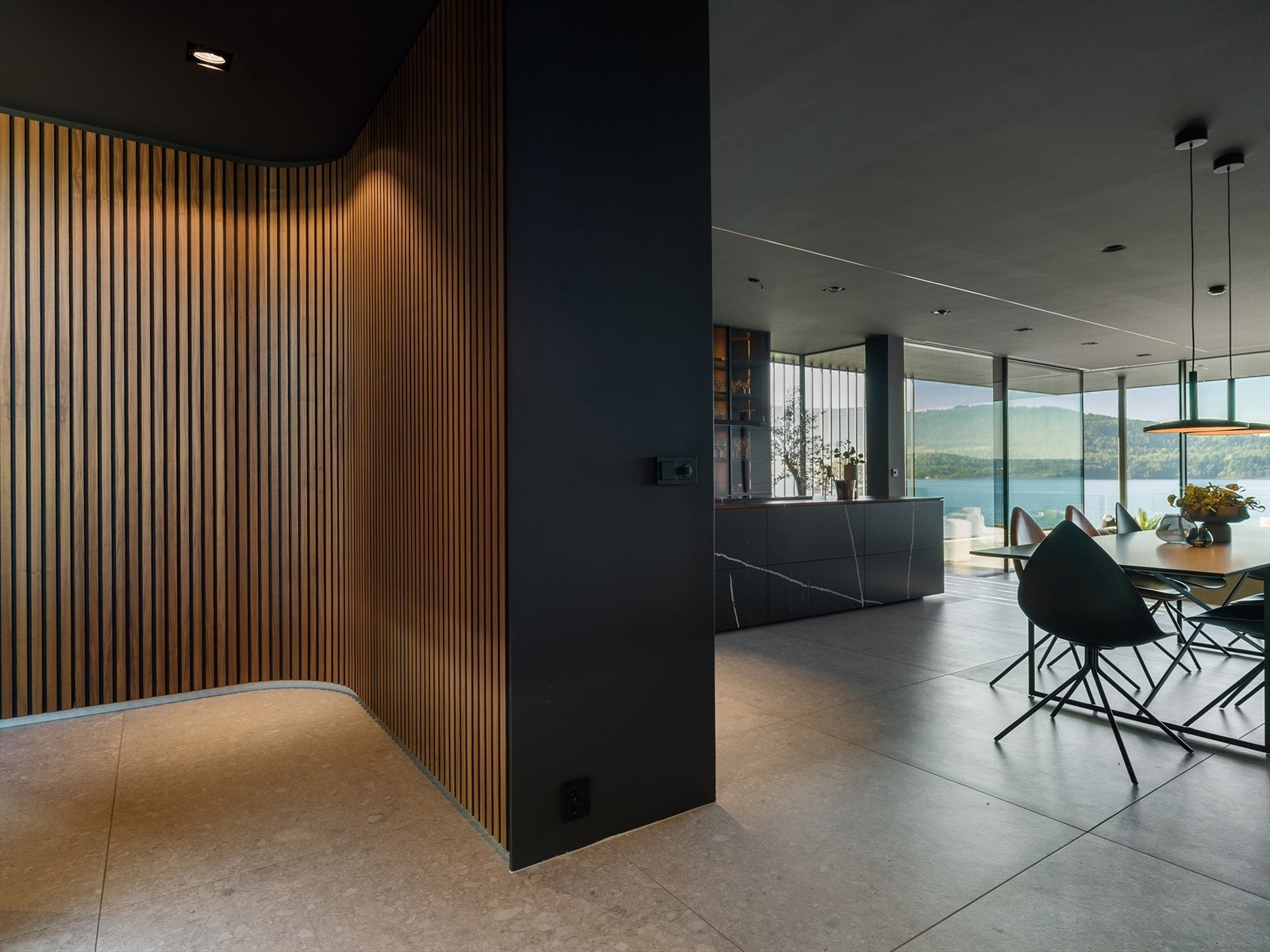 Skjult garderobe med gjennomført design: I entréen er det plassbygget en skjult garderobe med valnøtt spilefronter og Blum Legrabox-skuffer. Galleribilde