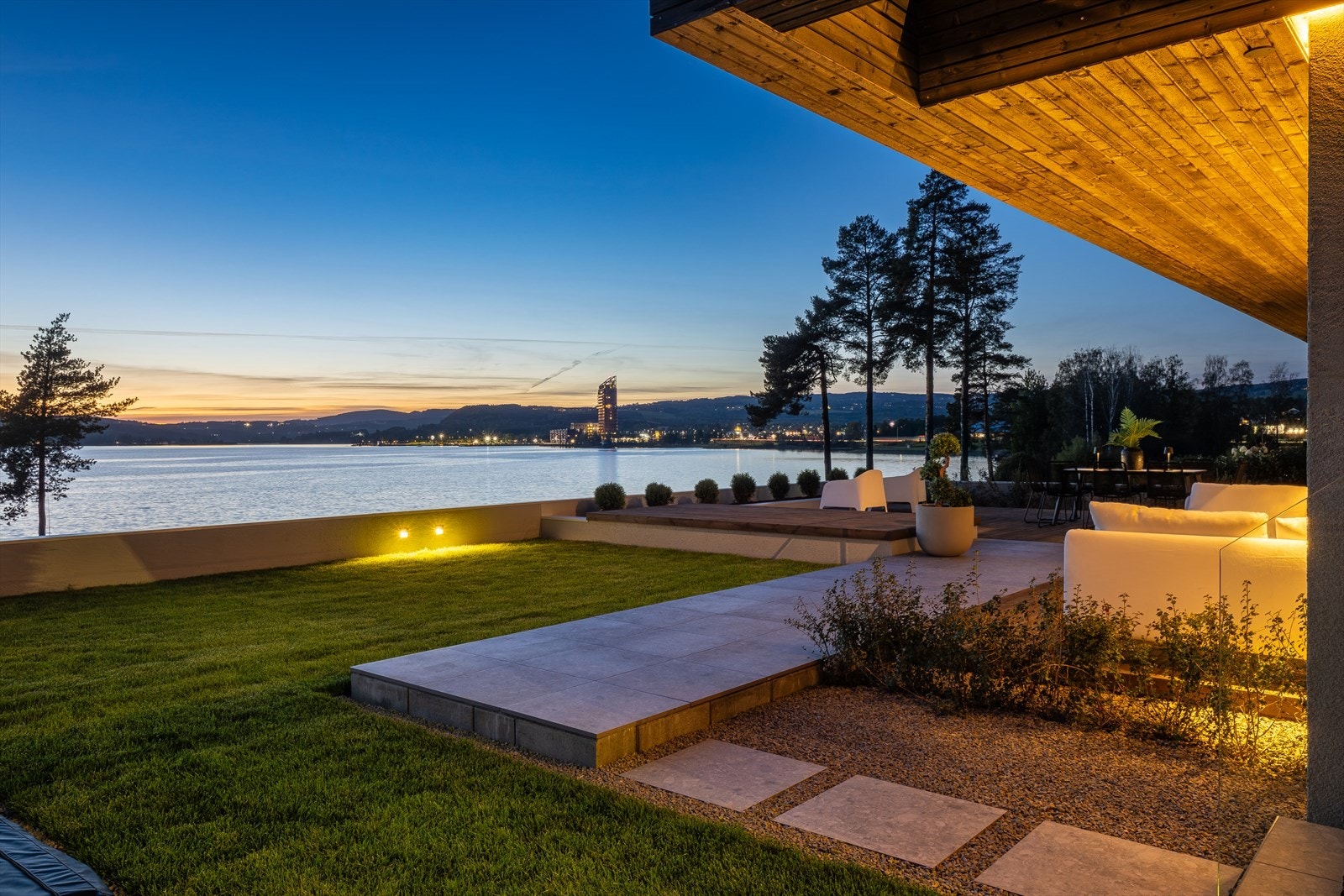 Fasade og hage lyssettes med innfelte LED-striper og diskrete armaturer, som fremhever materialvalg og arkitektur - og gir eiendommen et eksklusivt uttrykk også etter mørkets frembrudd Galleribilde