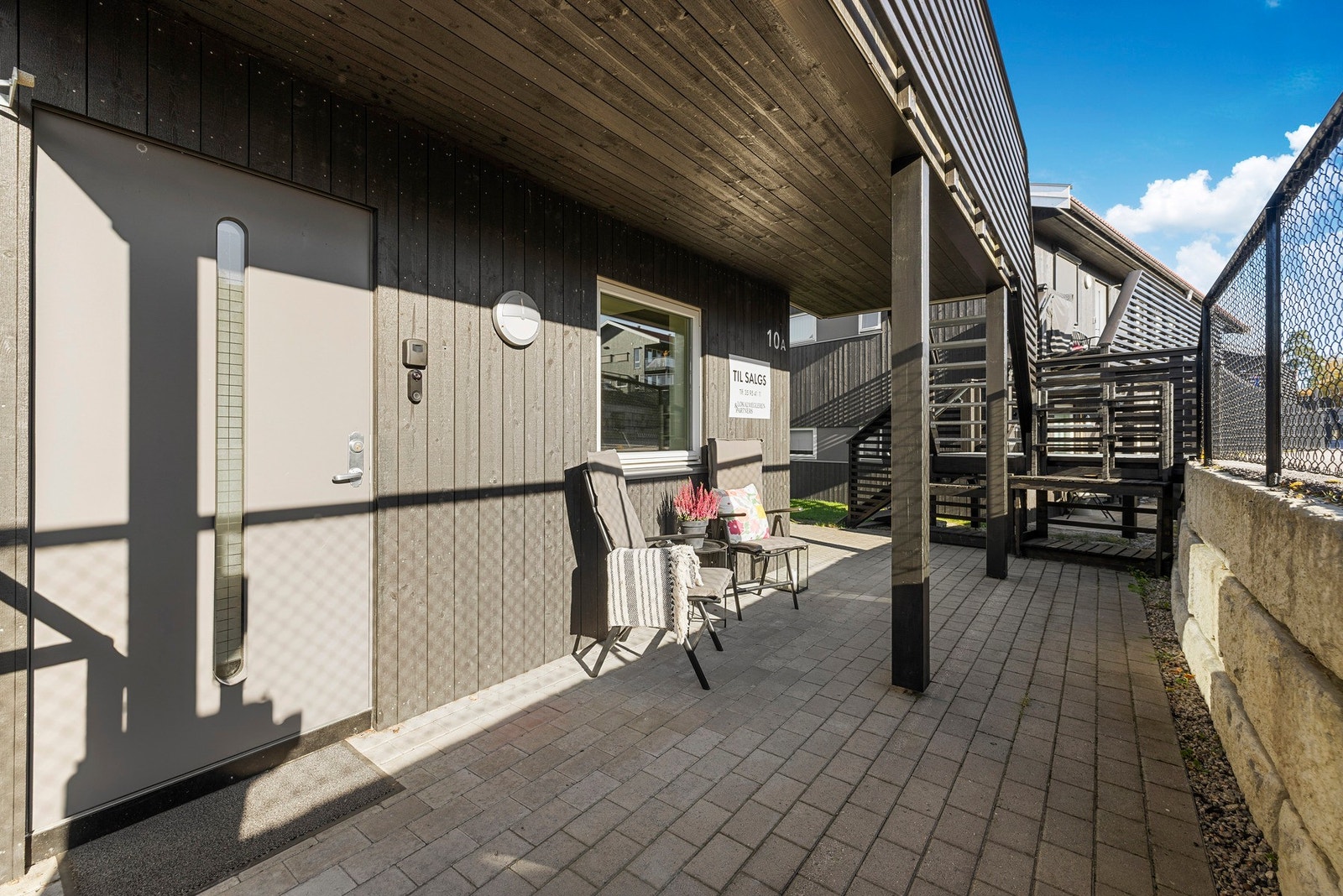 Hyggelig uteplass ved inngangsparti lagt med belegningsstein. Galleribilde