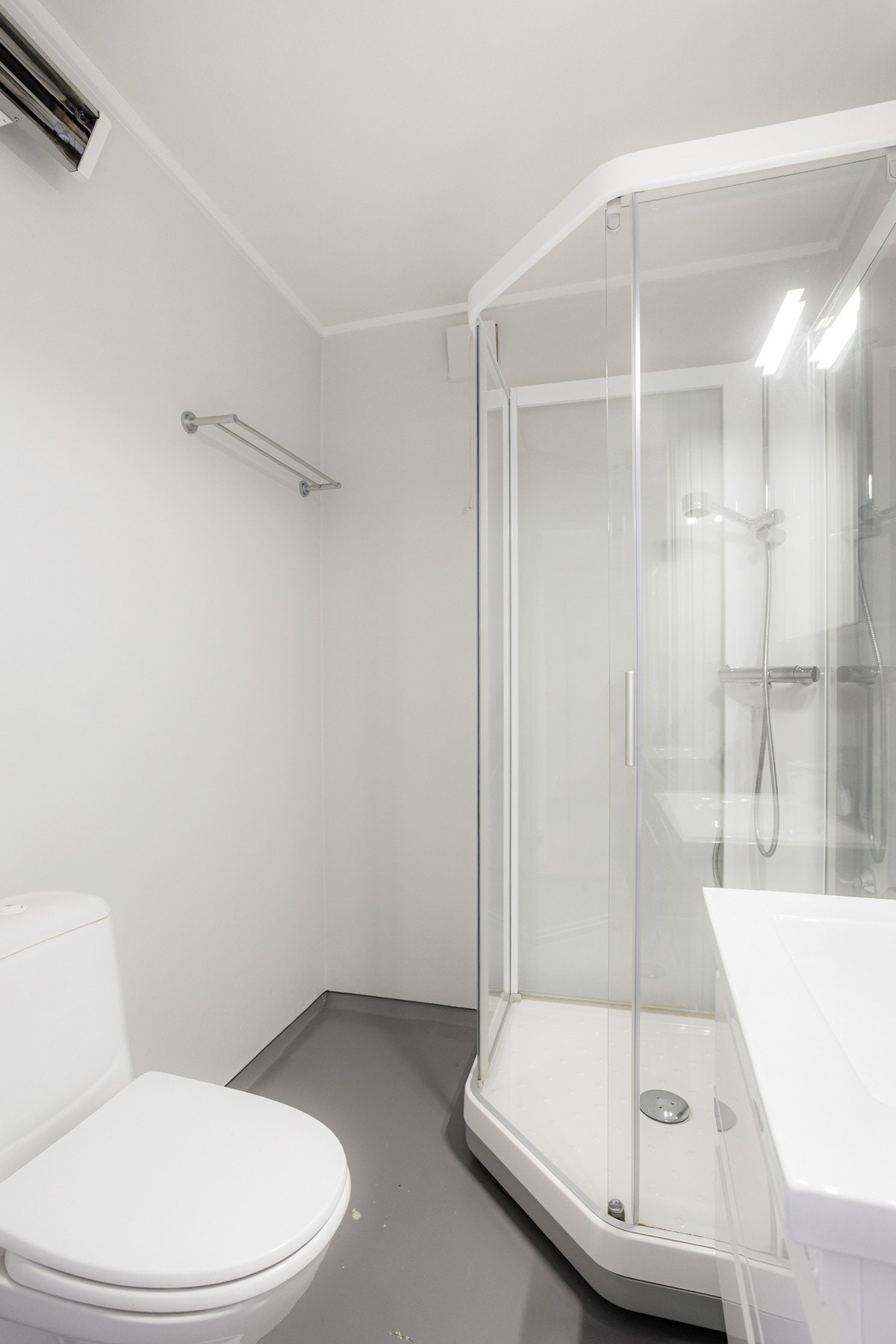 Badet har toalett, gulvbelegg og dusjkabinett Galleribilde