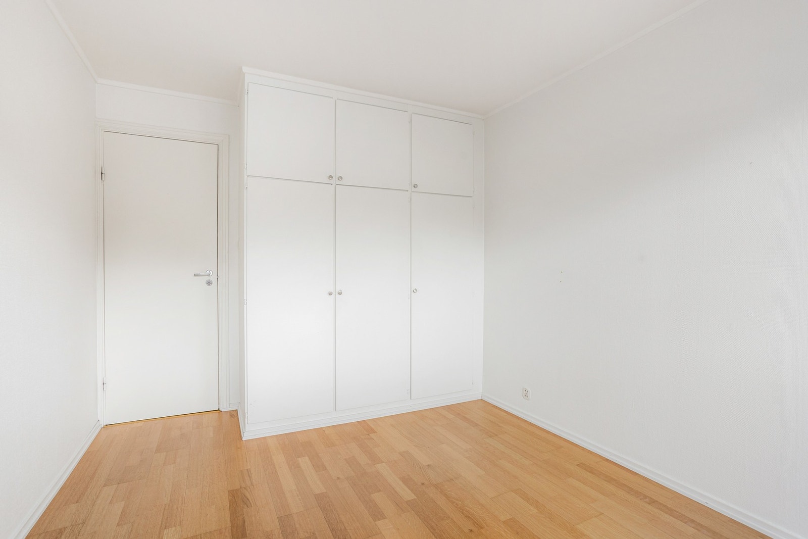 Veggene er hvitmalte, og rommet har mye oppbevaring i et plassbygd garderobeskap med hvite fronte Galleribilde