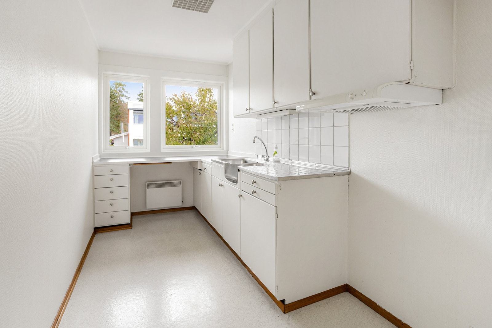 Leiligheten har et separat kjøkken med gulvbelegg, hvite vegger og gode lysforhold Galleribilde