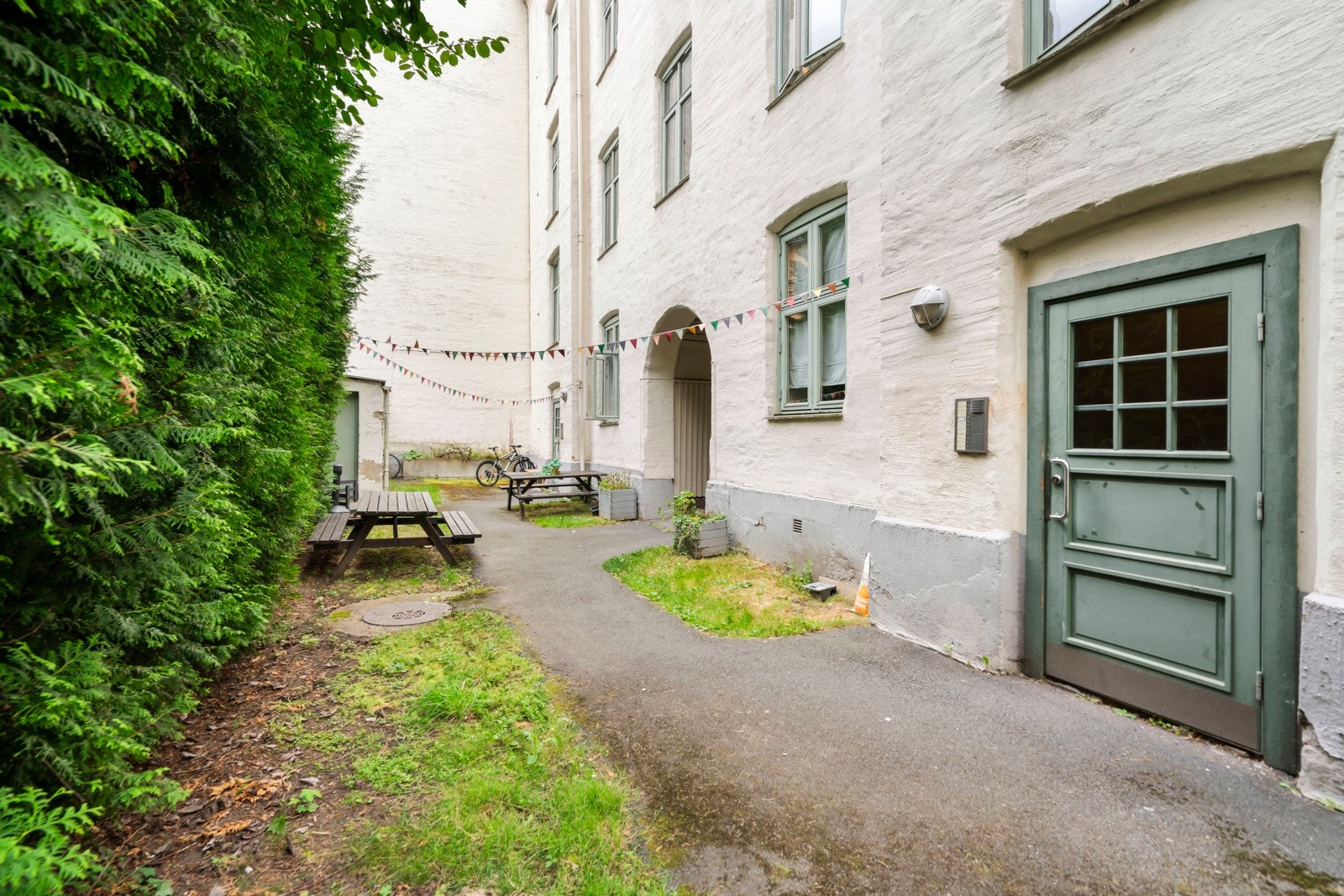 Opparbeidet tomt med asfalt og beplantning. Det er felles sykkelparkering i bakgården samt sittegrupper til sosiale sammenkomster. Galleribilde