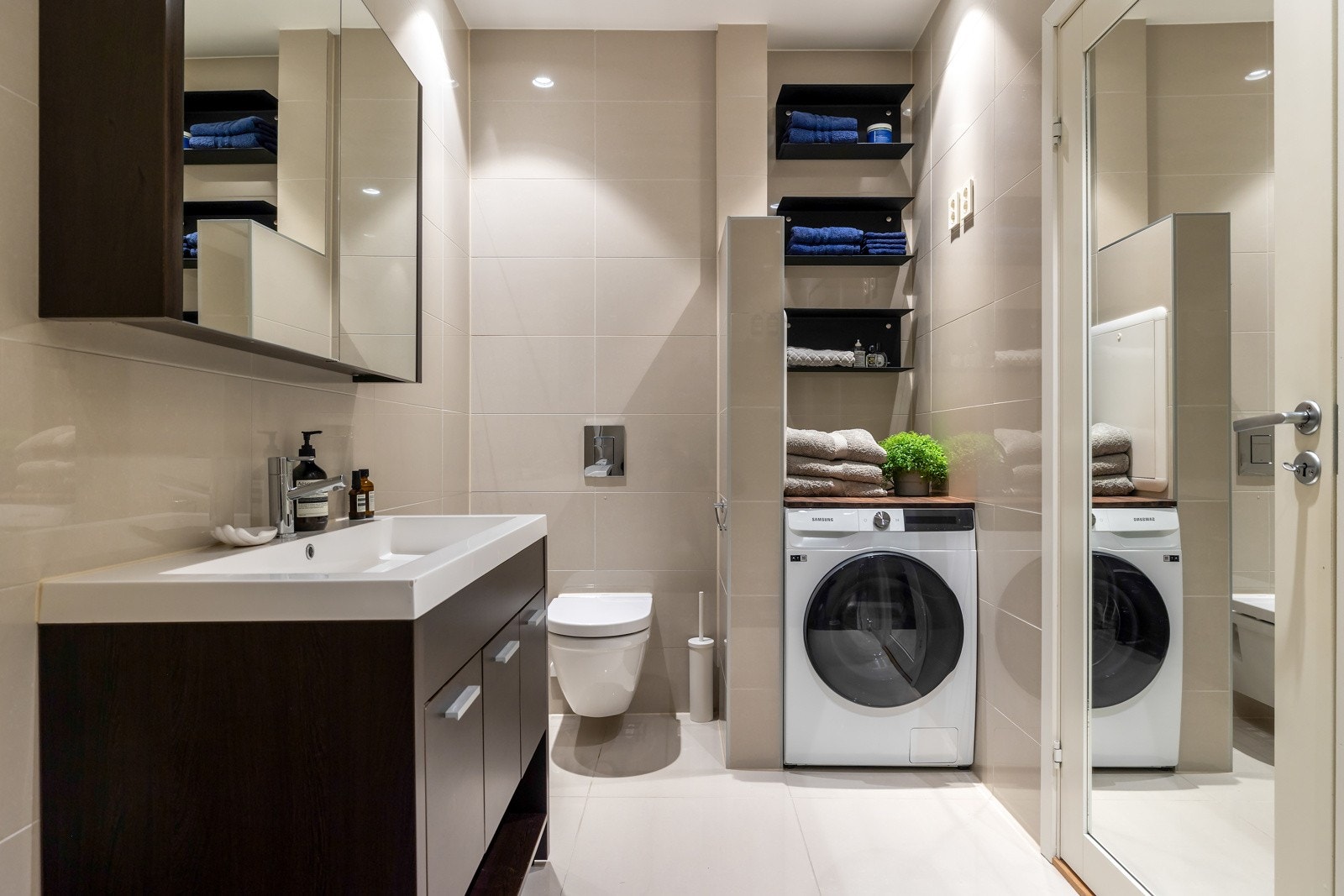Badet har også praktiske løsninger med opplegg for vaskemaskin og tørketrommel, samt hyller for oppbevaring av håndklær og utstyr. Galleribilde
