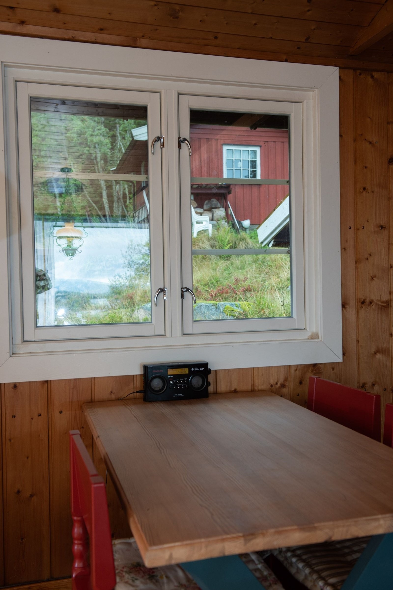 Spisebord i stue med utsikt opp mot gjestehytta. Galleribilde