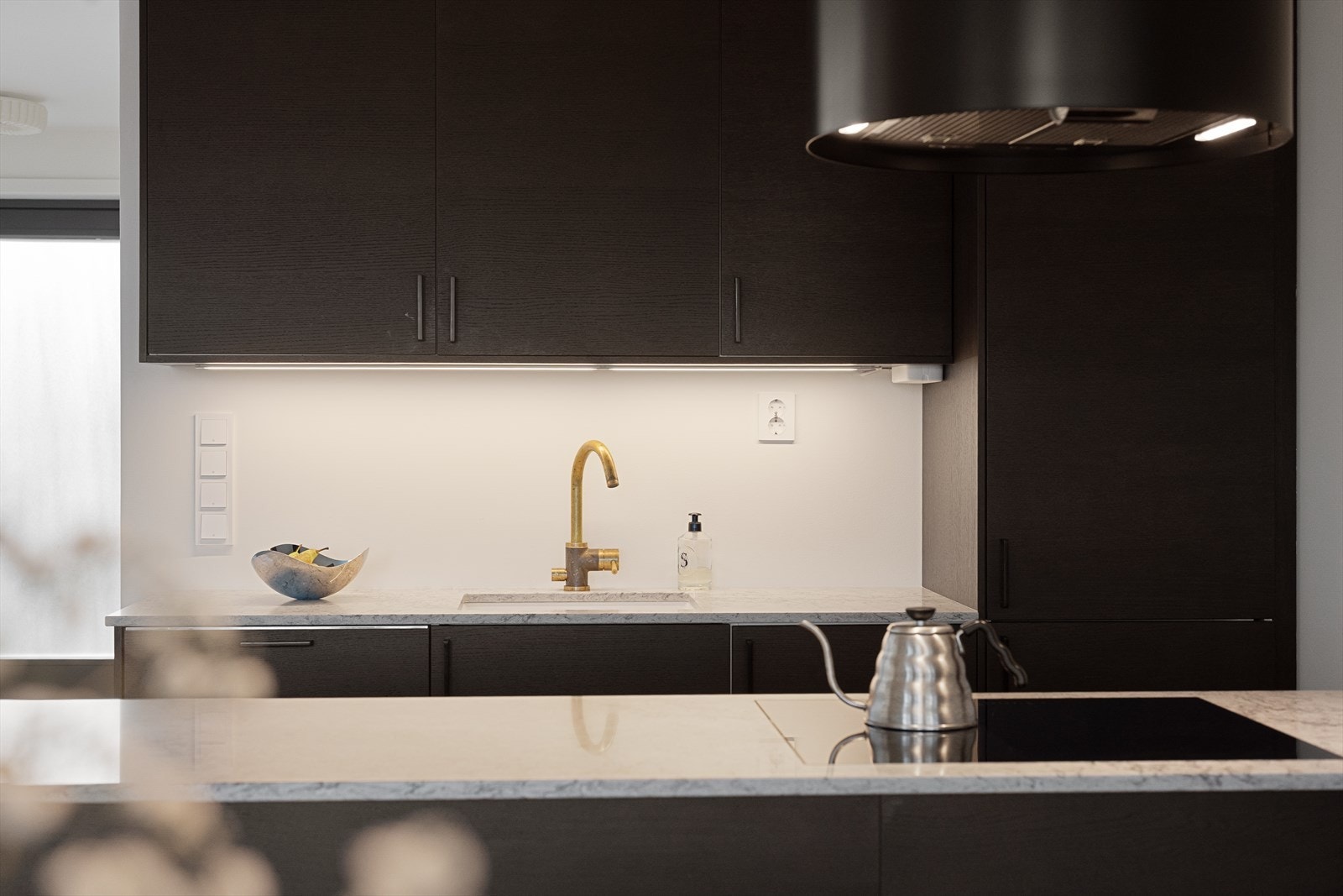 Benkeplaten er i stein (Caesarstone), og vaskesonen har nedfelt oppvaskkum med ettgreps, svingbart blandebatteri. Galleribilde