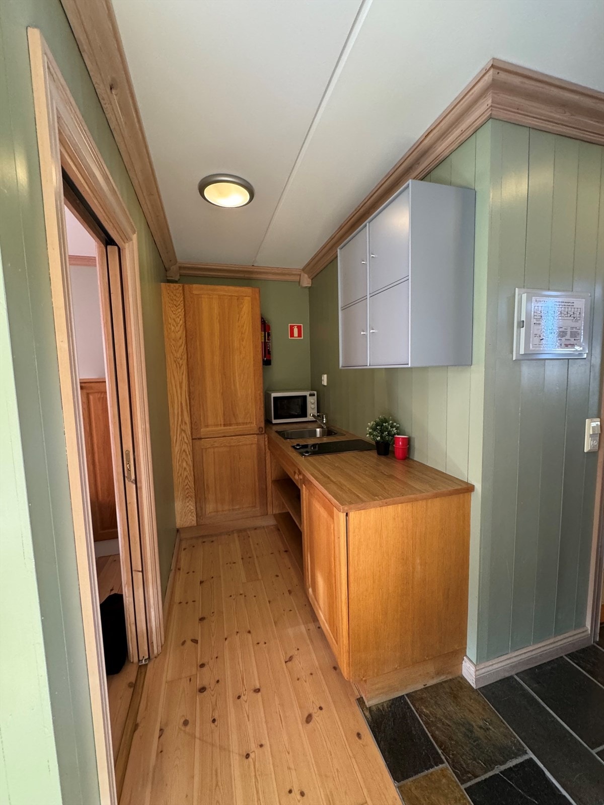 Praktisk kjøkkenløsning med god benkeplass, innredning i heltre og integrerte hvitevarer - perfekt tilpasset leilighetens størrelse og bruk. Galleribilde