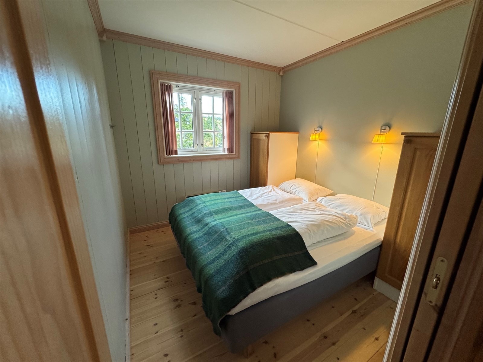 Hovedsoverom med dobbeltseng, garderobeskap og vindu som slipper inn naturlig lys. Et trivelig rom med varm fjellhyttefølelse. Galleribilde