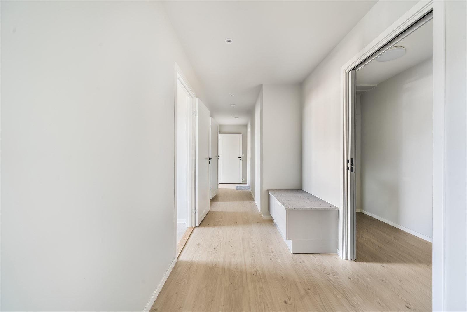 Gang med avkledningplass og skyvedør inn til mellomgangen hvor heisen kommer inn. Galleribilde