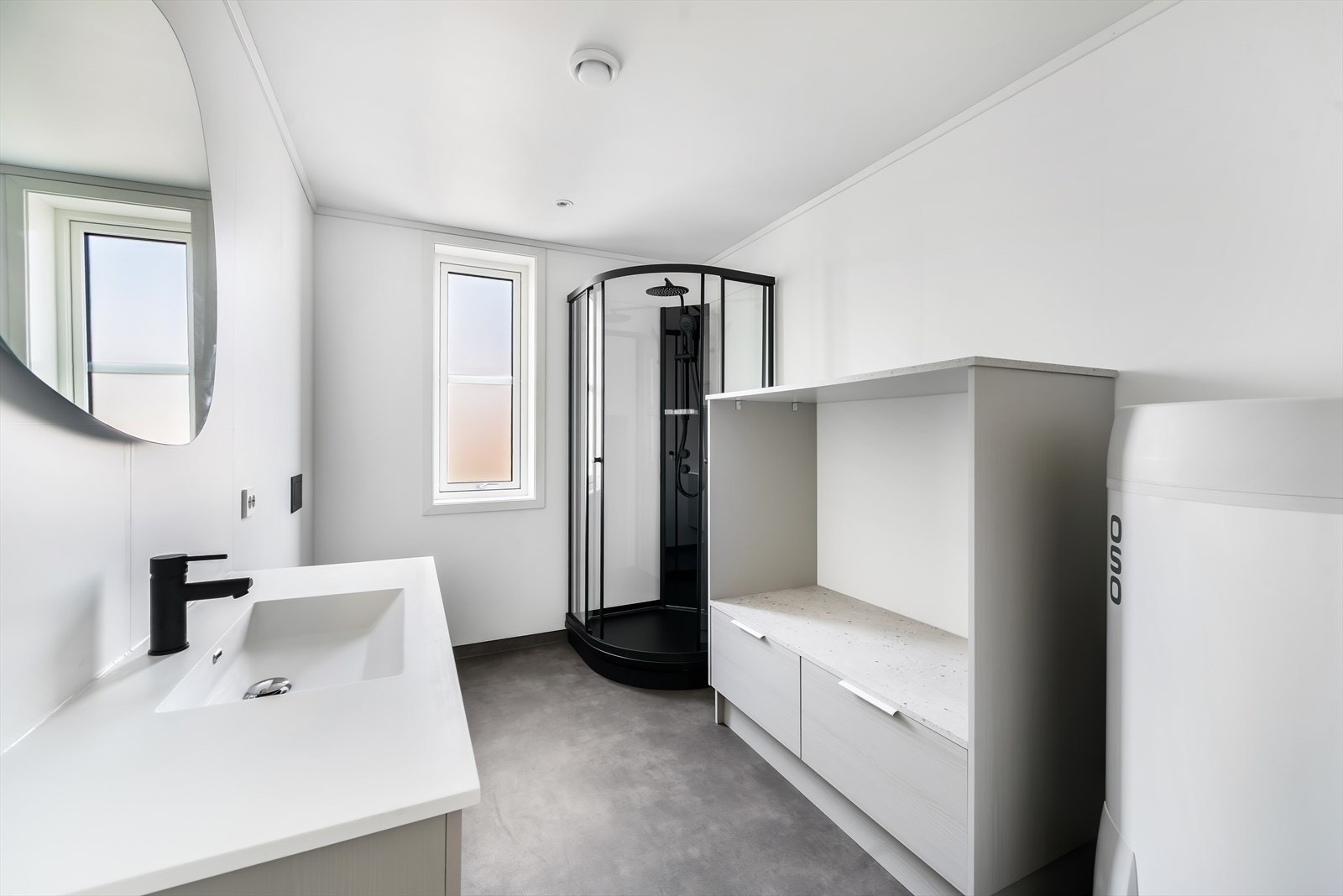 Pent kombinert bad og vaskerom. Innredet med baderomsinnredning, toalett, dusjkabinett, vvs og innredning til vaskemaskin og tørketrommel. Galleribilde