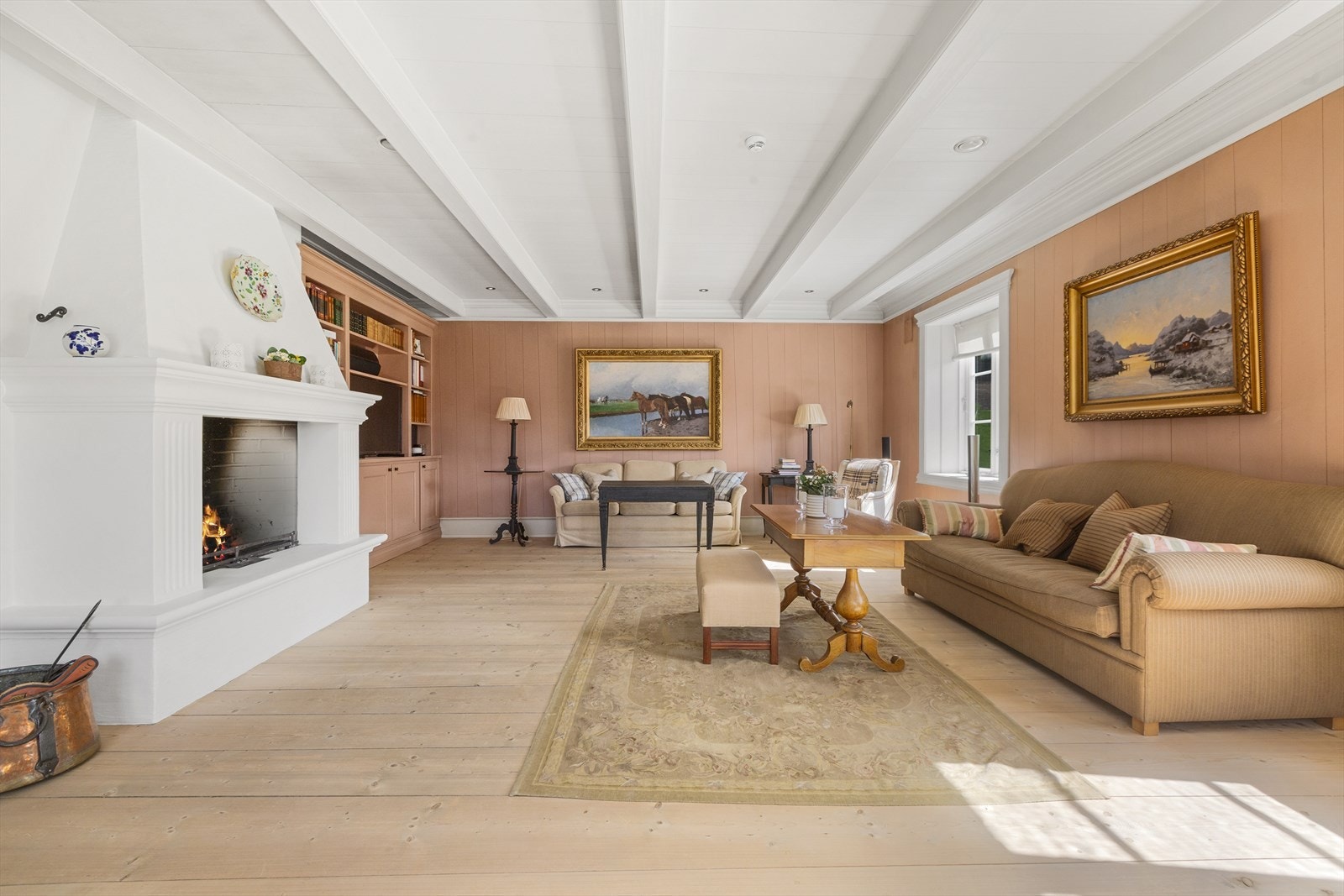 Hovedbygningens storstue med en flott plassbygget peis Galleribilde