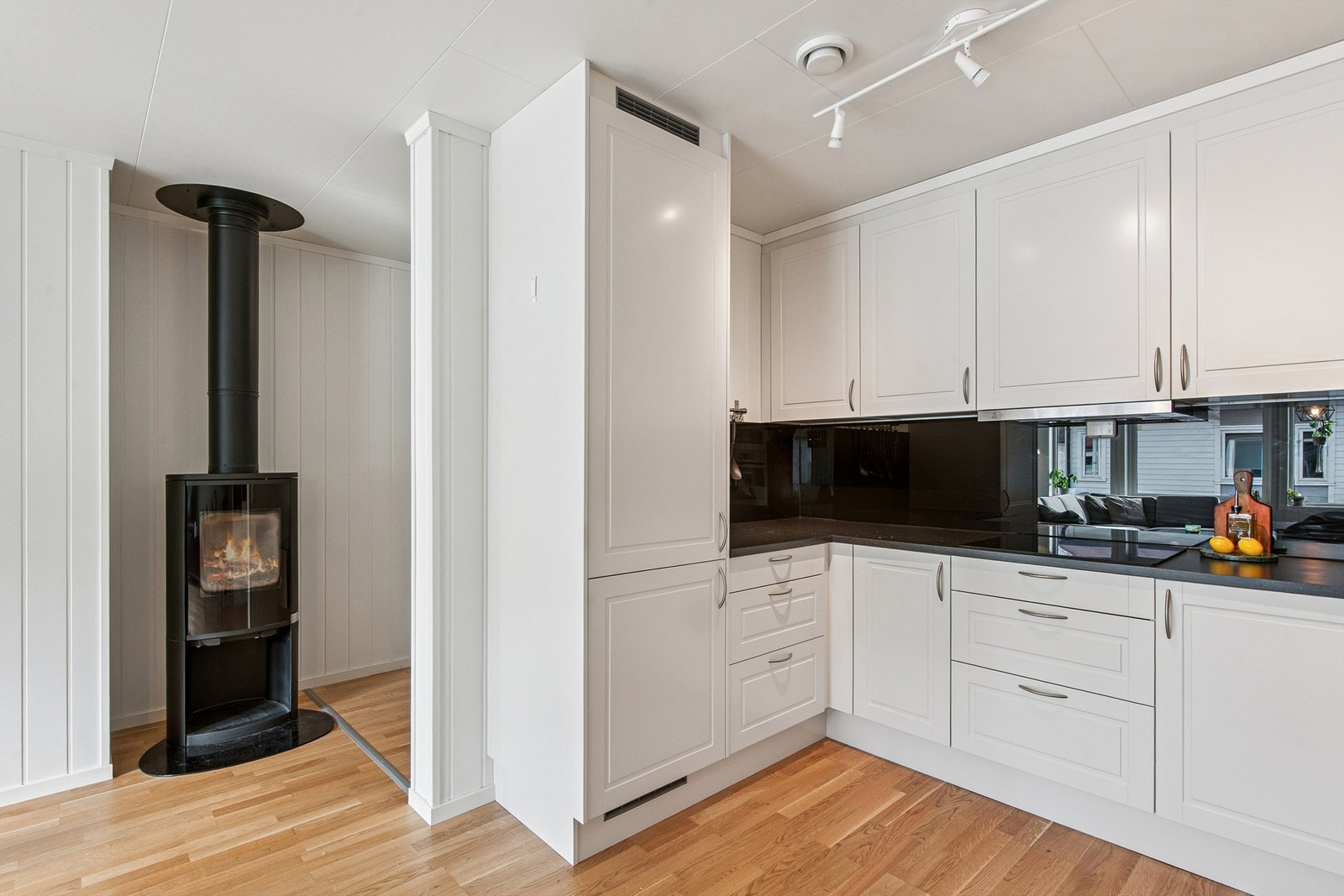 Fra kjøkkenet er det kort vei til vedovnen i stuen. Galleribilde