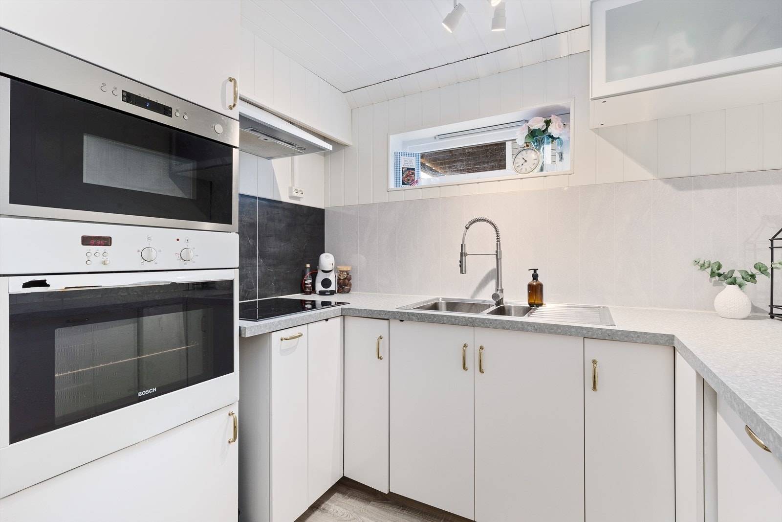 Benkeplaten er av laminat med våtromsplate på vegg over vask og kokesone. Galleribilde