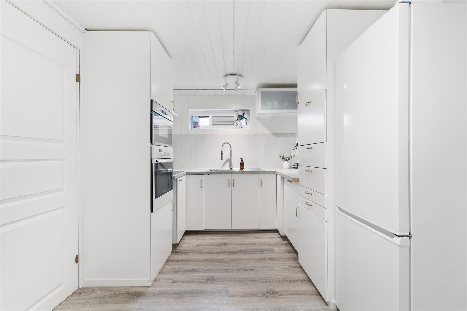 Kjøkkenet i hybelen har innredning med glatte fronter. Galleribilde