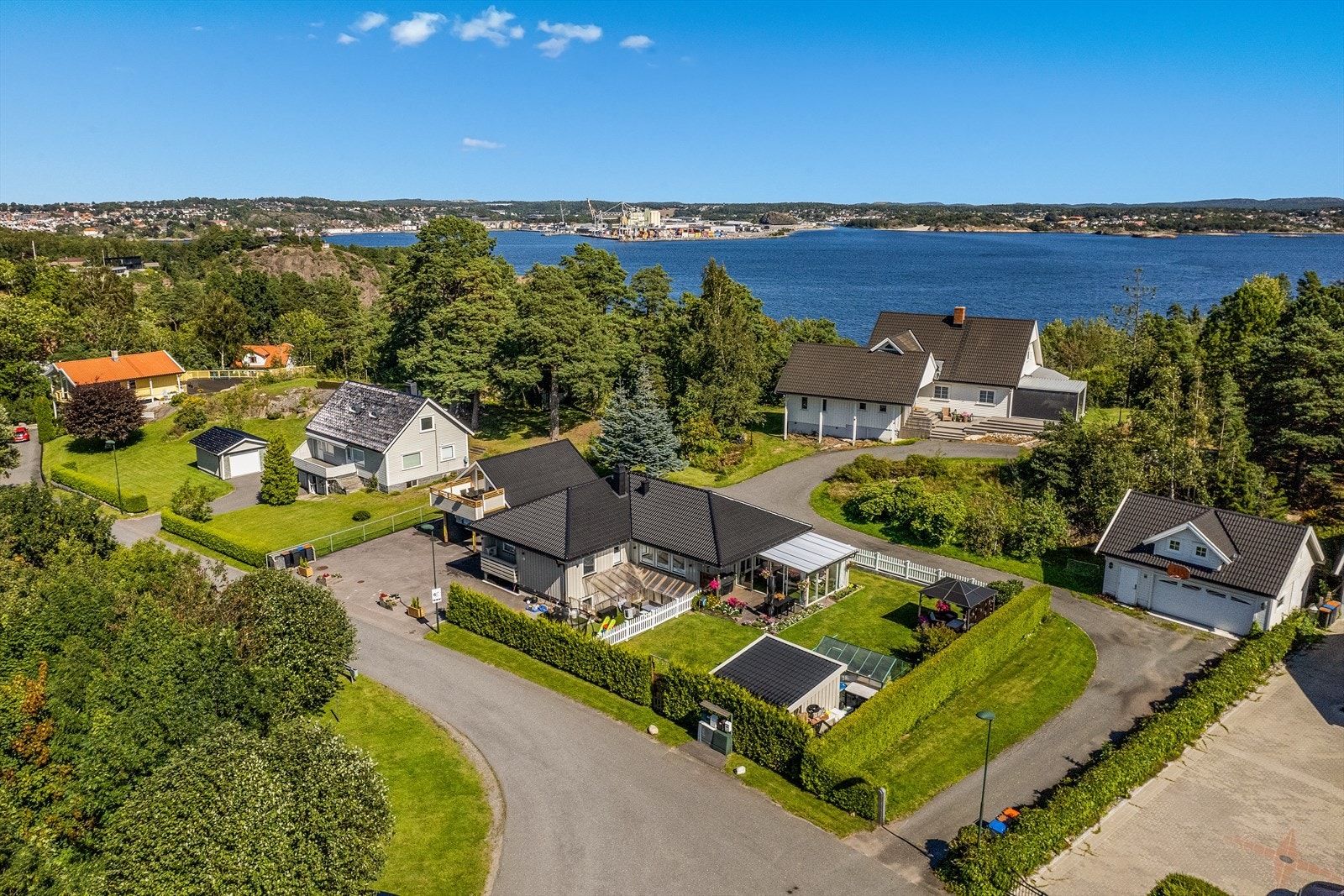 Denne nydelige eiendommen inkluderer en stor gressplen, omgitt av vakkert plasserte busker, trær og blomster. Den asfalterte innkjørselen gir et innbydende preg. Galleribilde