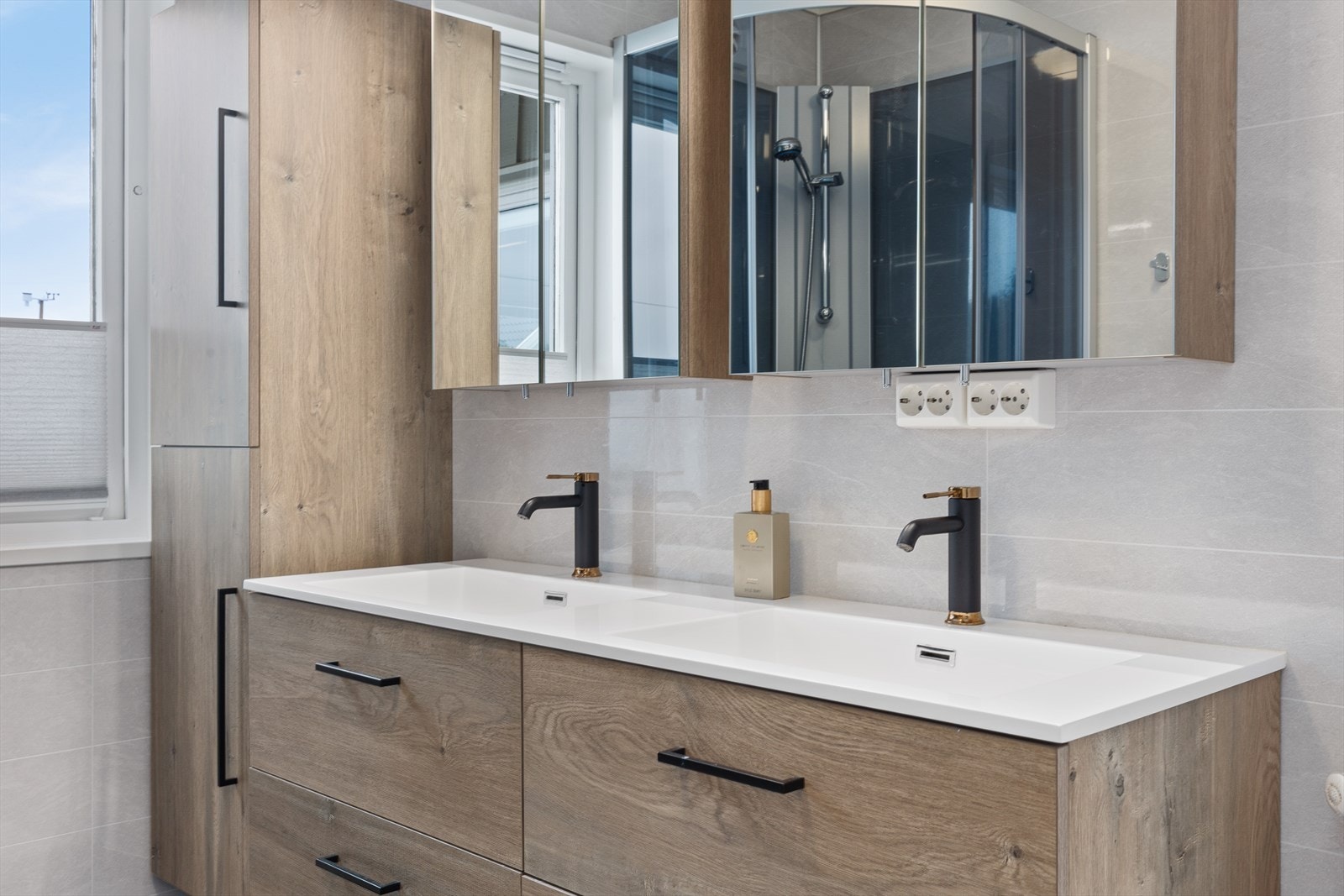 Baderommet er innredet med dobbelt servantskap, toalett og dusjkabinett. Galleribilde