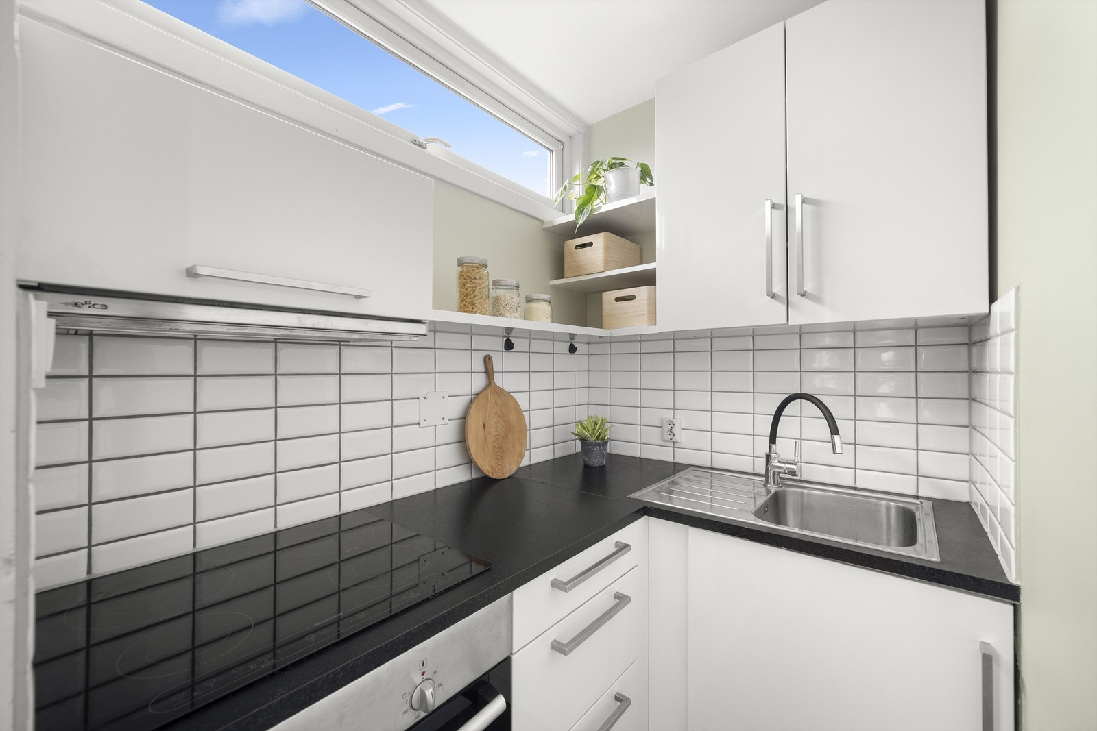 Kjøkkeninnredning med glatte fronter og laminat benkeplate med nedfelt vaskekum. Galleribilde