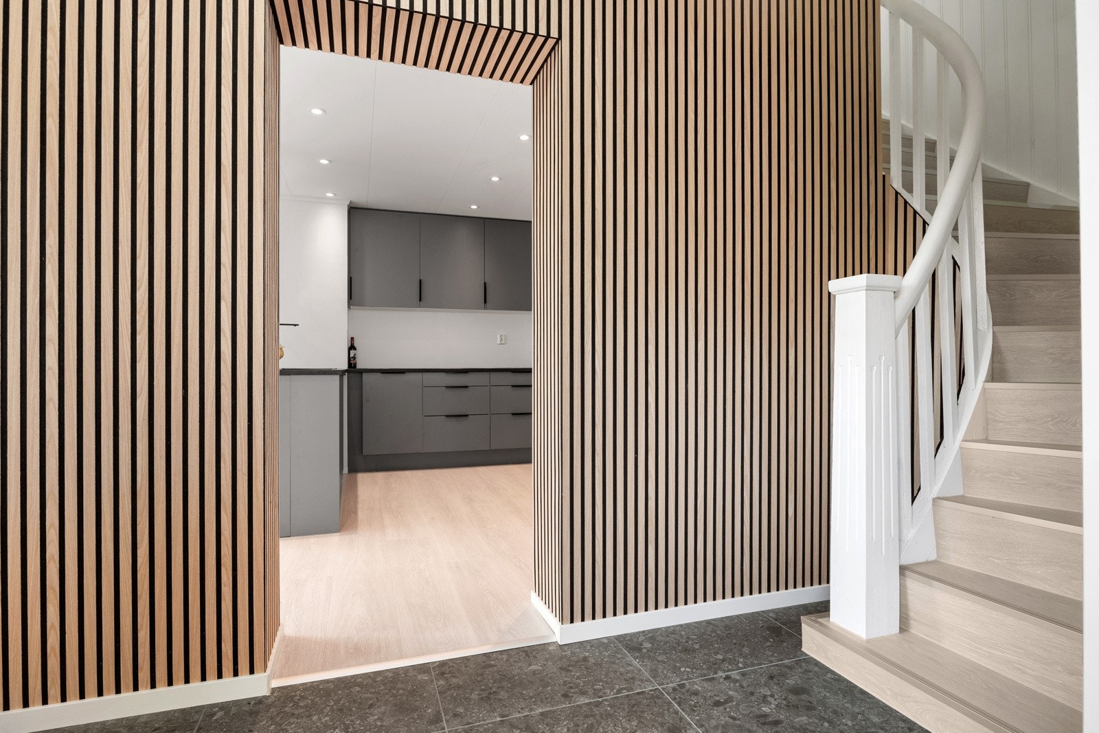 Romslig gang med keramiske fliser, varmekabler og moderne spilevegg. Galleribilde