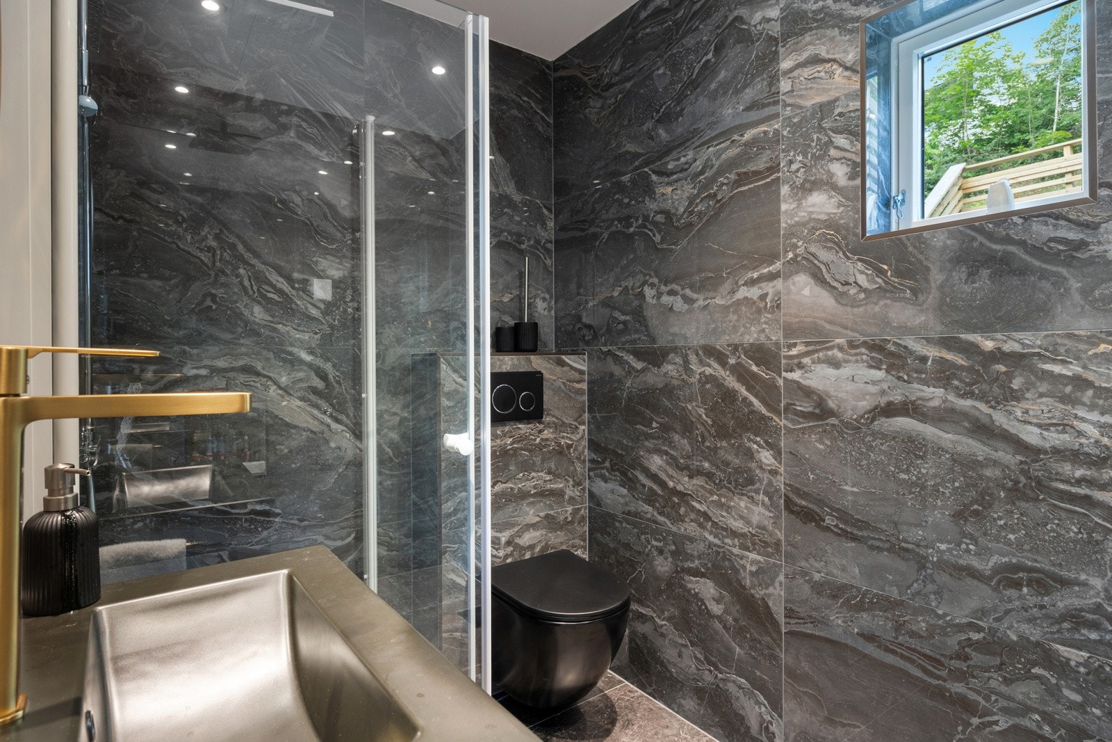 Dusjnisje, servant med underskap, toalett og opplegg for vaskemaskin. Galleribilde