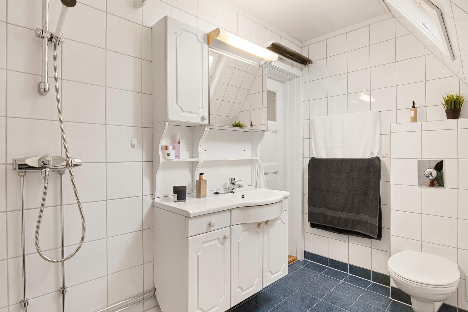 Det er flislagt gulv med elektriske varmekabler, flislagte veggflater og malt innvendig tak. Galleribilde