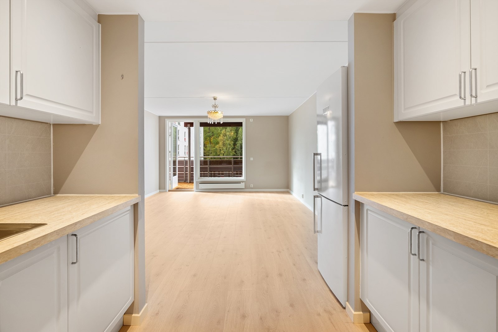 Plasseringen langs to vegger gir både godt med skapplass og funksjonelle arbeidsflater. Galleribilde