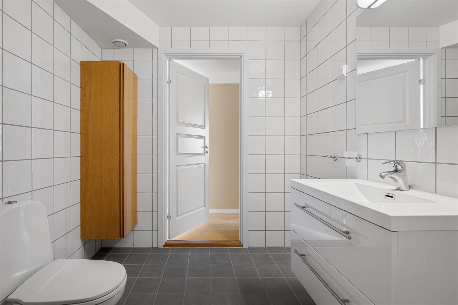 Overflatene er holdt i nøytrale farger, noe som gir et tidløst uttrykk og gjør badet enkelt å møblere med tilbehør. Galleribilde