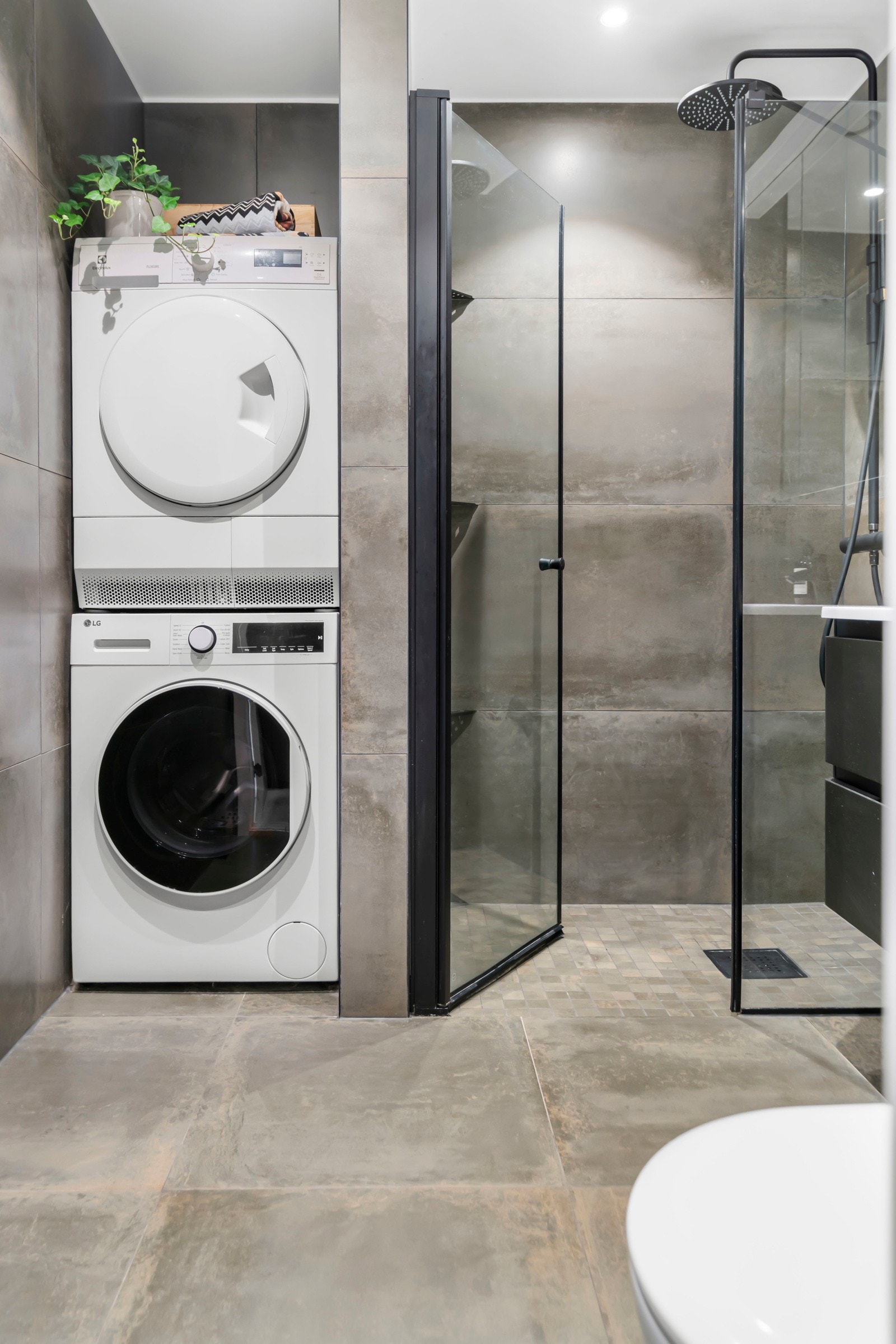 Plassbygd nisje til vaskemaskin og tørketrommel i tillegg til en stor dusjsone. Galleribilde