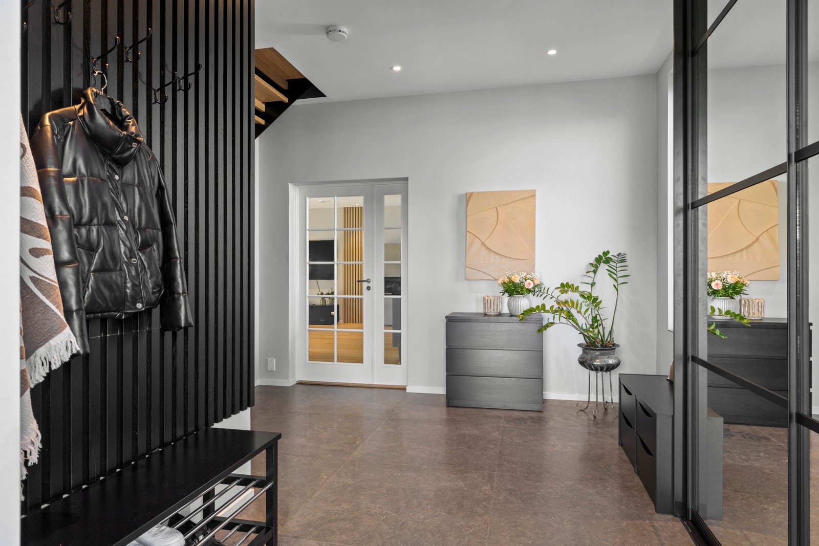 Velkommen inn. Gangen er romslig, og praktisk utformet. Gulvet har flislagte flater, mens vegger og himling er malt opp i moderne farger. Galleribilde