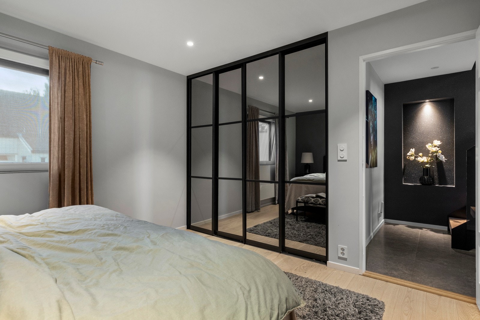 Soverom 1 har god plass til en dobbeltseng med tilhørende nattbord. Bak skyvedør med speilfront har rommet et tilhørende omkledningsrom. Galleribilde